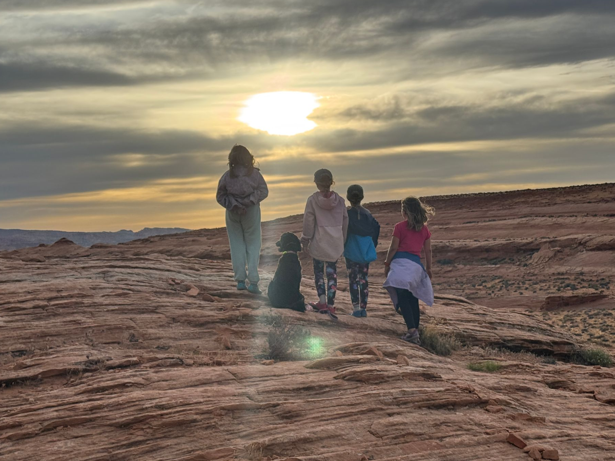 Their classroom looks a little different Four sisters and their dog walking across red rock terrain at sunset during a family hike