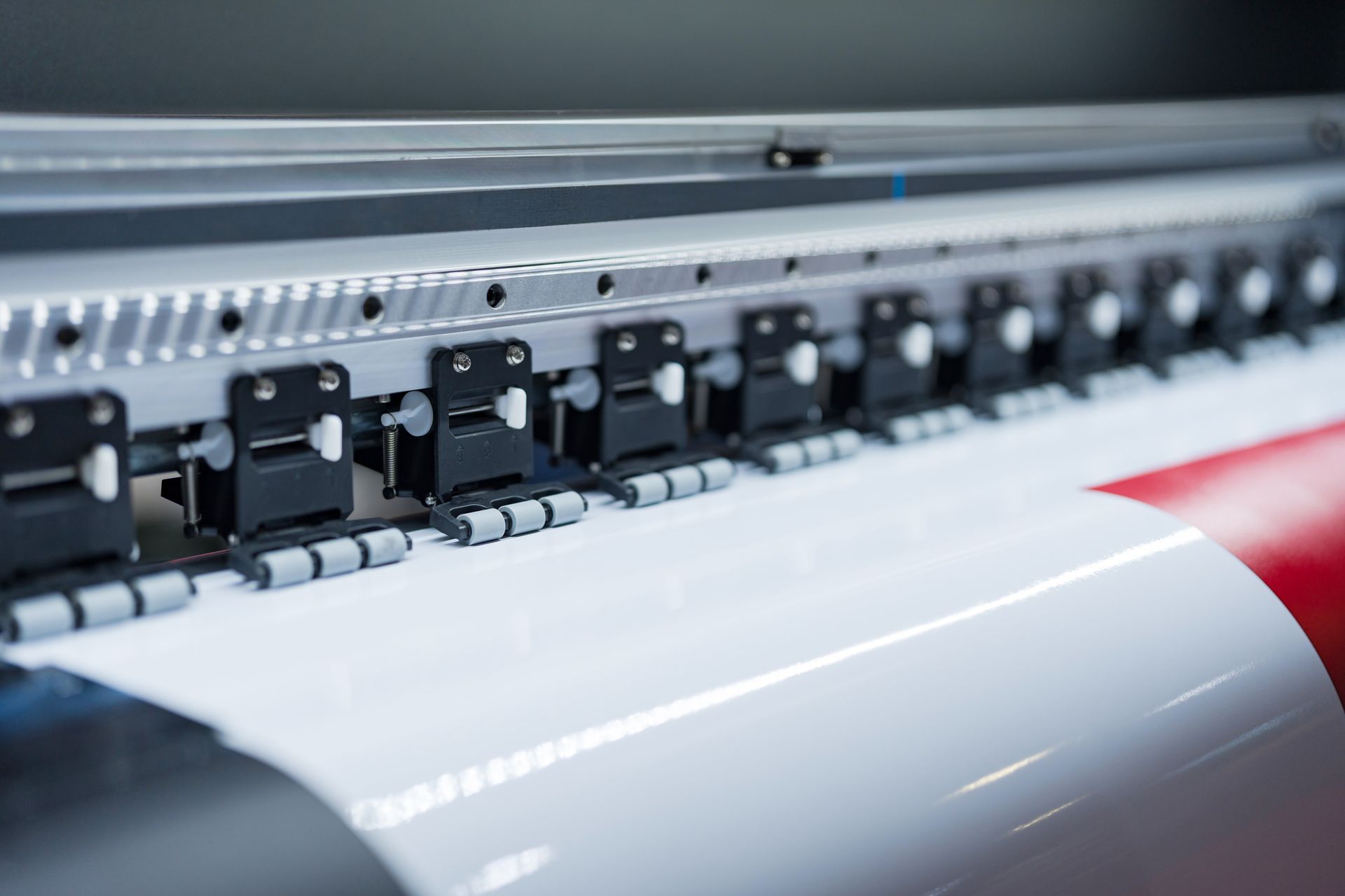 Close up of large format printer heads in action printing on wide vinyl material