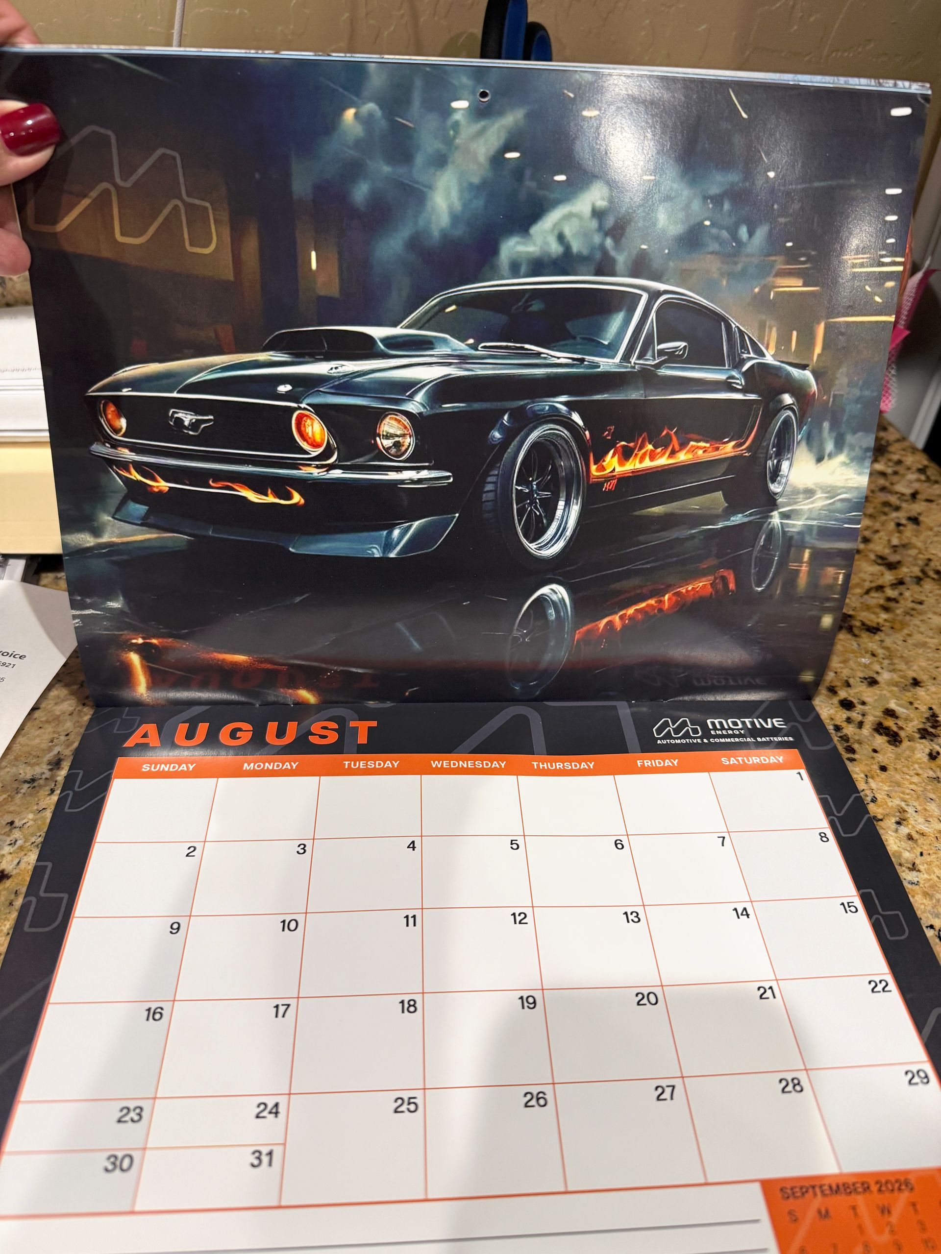 Black muscle car wall calendar showing August with an orange-accented grid.