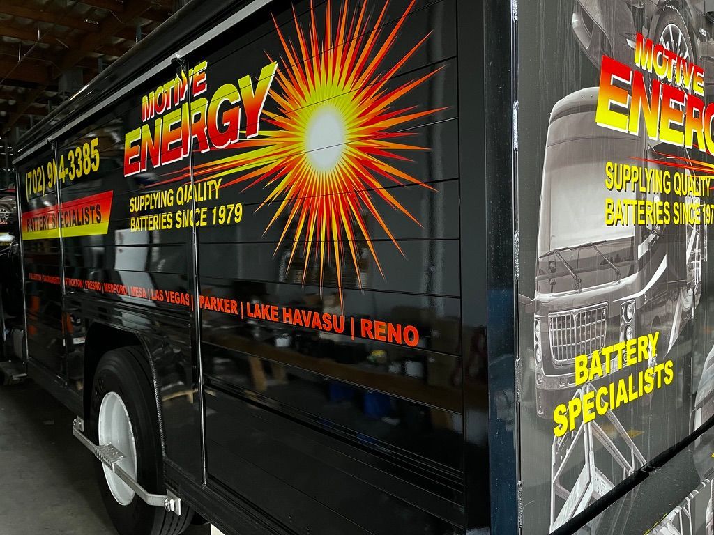 Motive Energy vehicle wrap design with bold sunburst logo and battery specialist branding