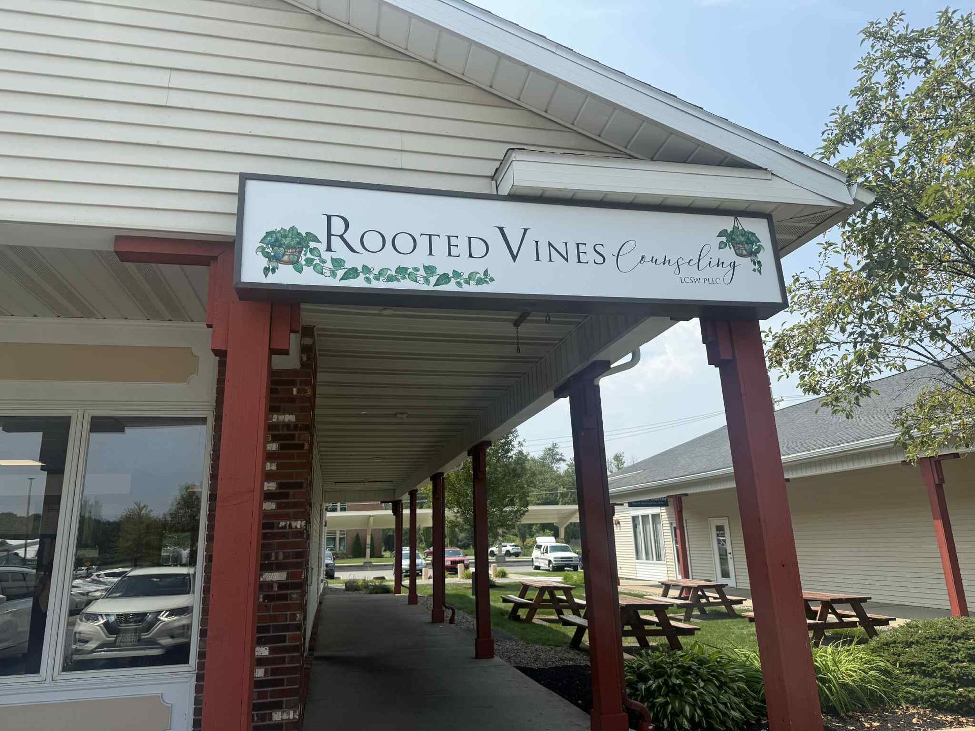 Rooted Vines Counseling storefront sign with hand-painted vine and ivy illustration