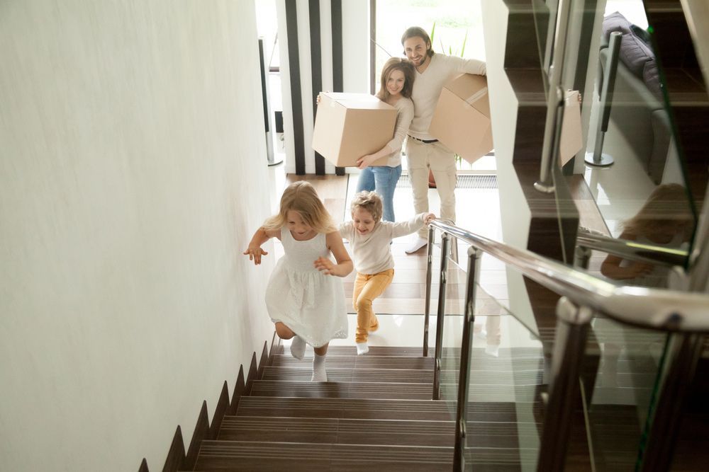 A Family Is Moving Into a New Home and Running Down the Stairs — A M Conveyancing Pty Ltd In Northern Rivers, NSW