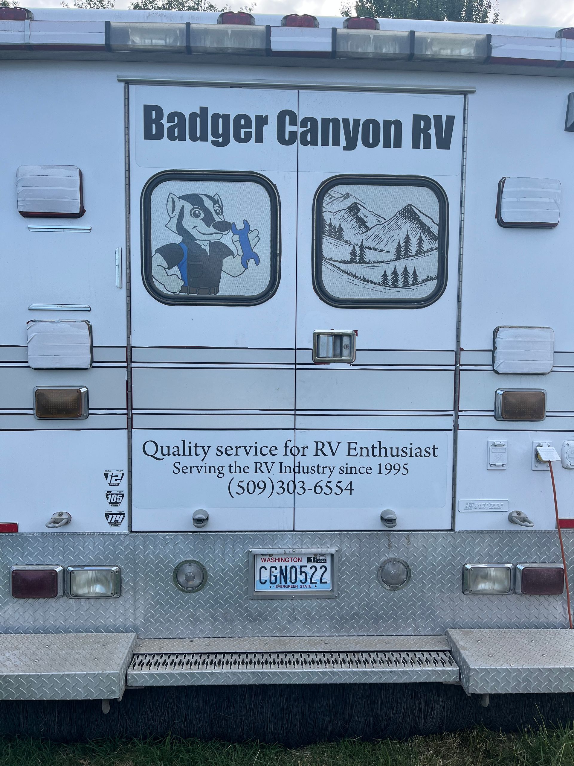 White Badger Canyon RV service vehicle rear doors, logo, contact info, and license plate.