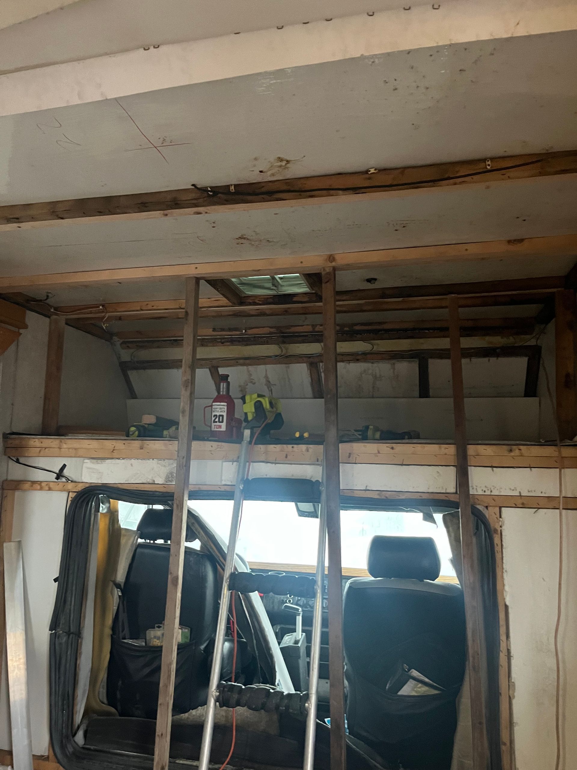 Interior of a vehicle undergoing renovation; exposed beams and seating visible.