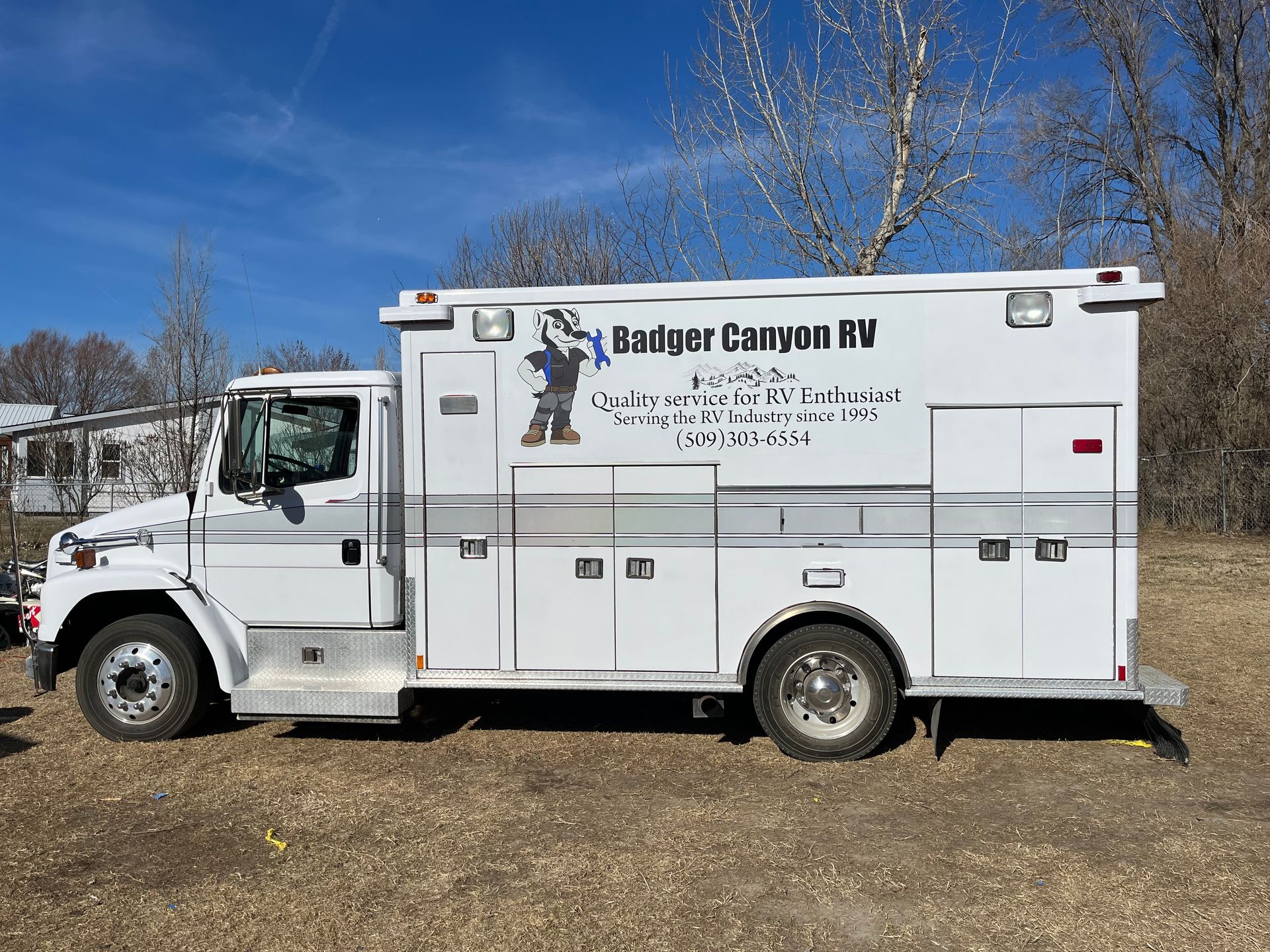 White Badger Canyon RV service truck parked outdoors on a sunny day.