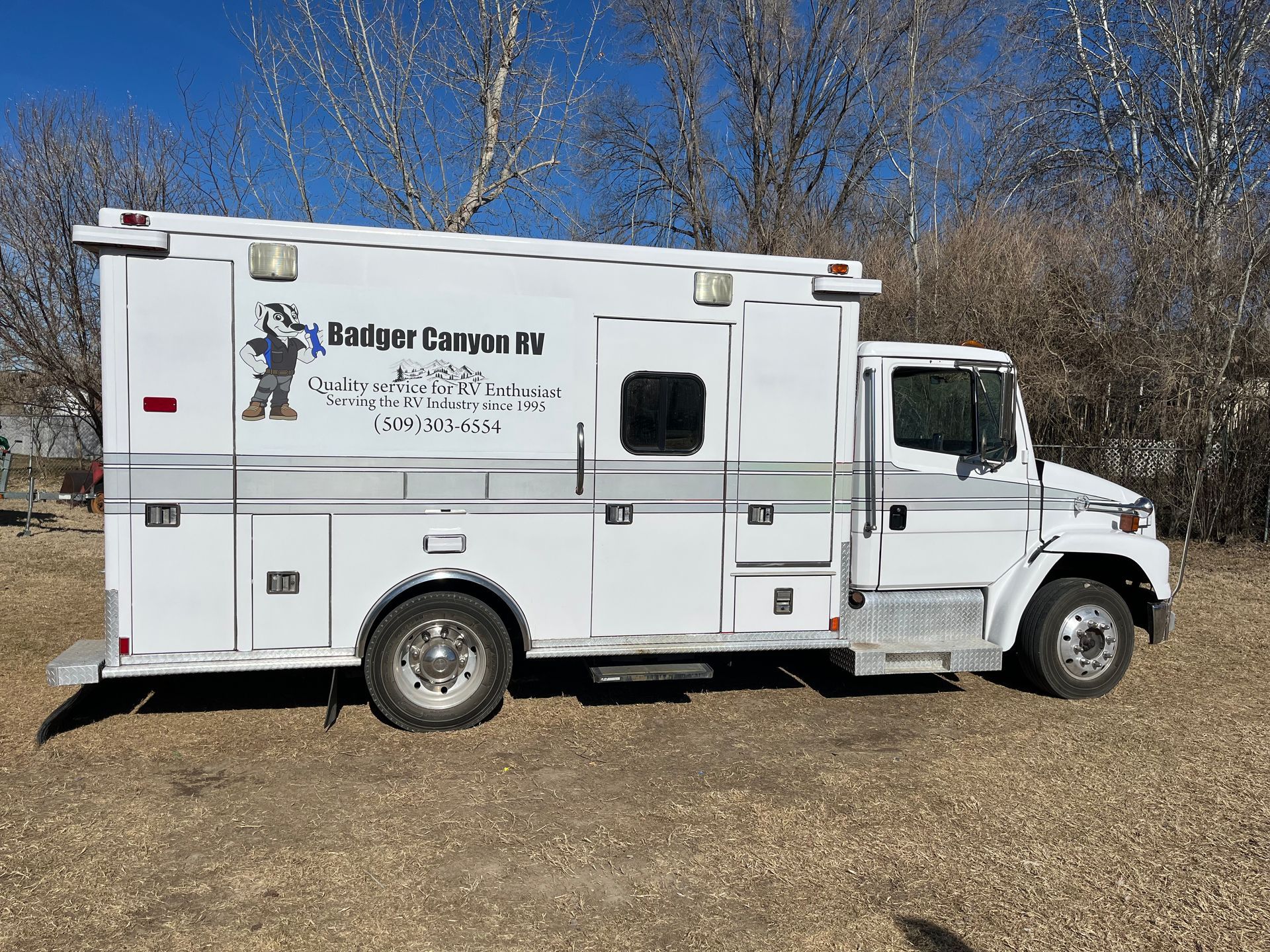 White Badger Canyon RV service truck parked outdoors.