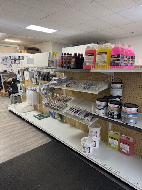Shelves in a store filled with various car fluids, paints, and auto parts.