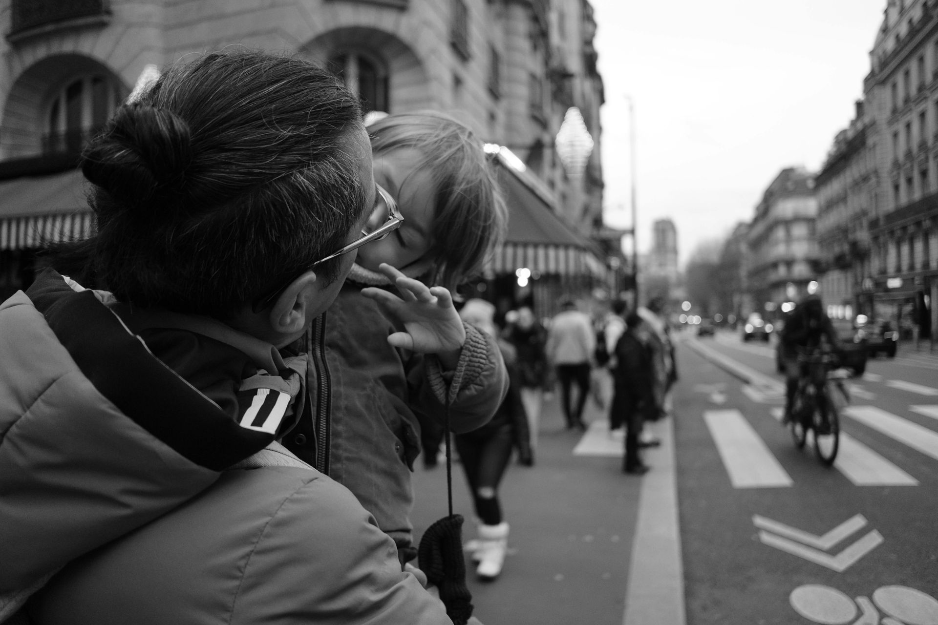 Du temps précieux entre père et enfant un père est au bord de la route en ville et a son enfant sur ses bras. L'enfant semble dormir, il a max 1,5 ans.