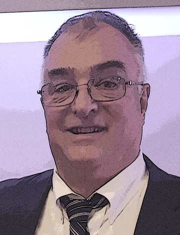Smiling man in a dark suit, white shirt, and striped tie wearing glasses against a light background