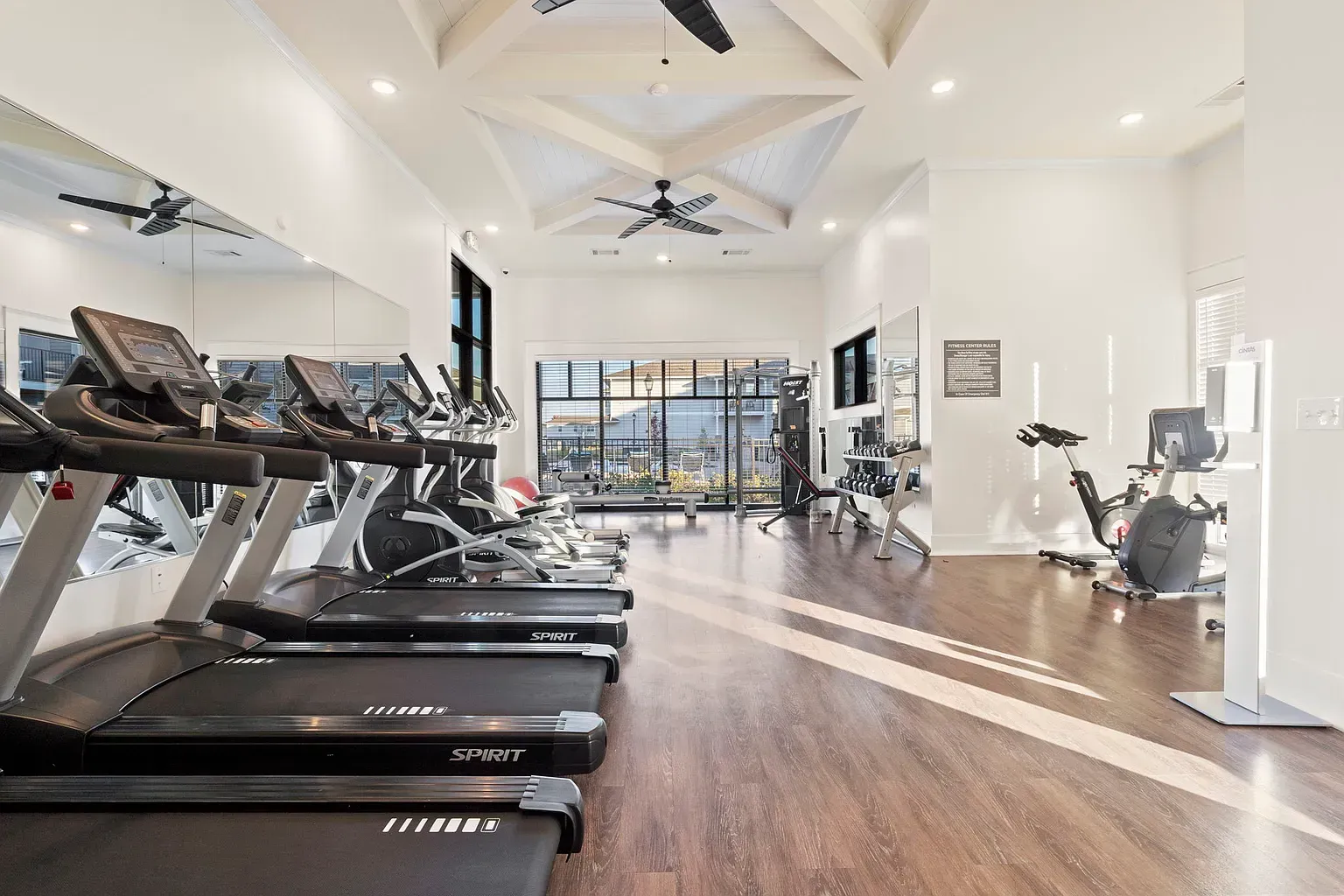 Bright community fitness center with treadmills and weight area.