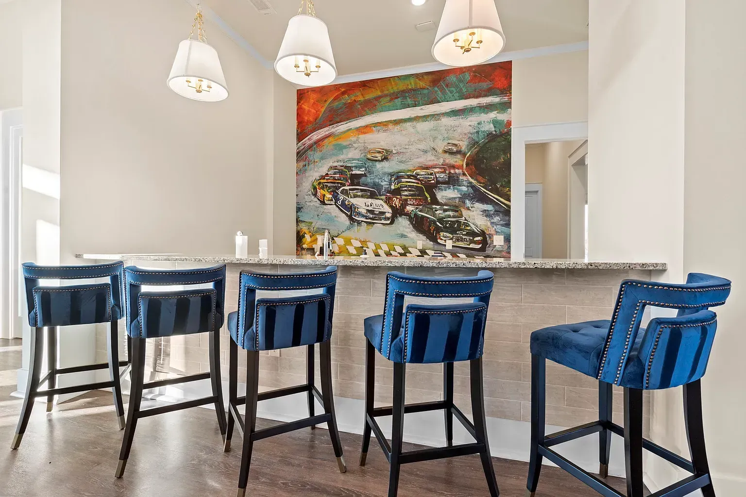 Bar counter with blue upholstered stools in a community lounge.