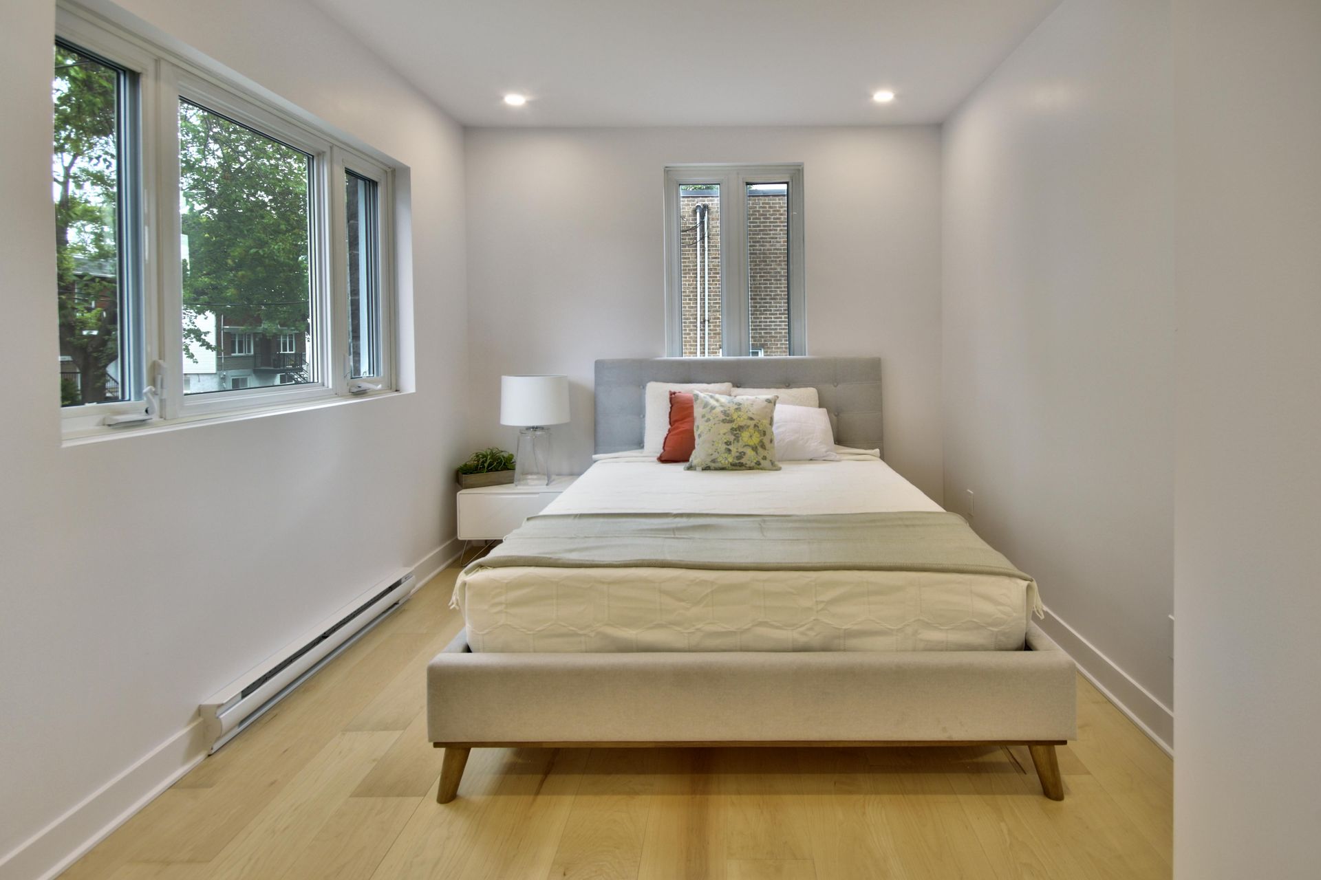 A bedroom with a bed and a lot of windows