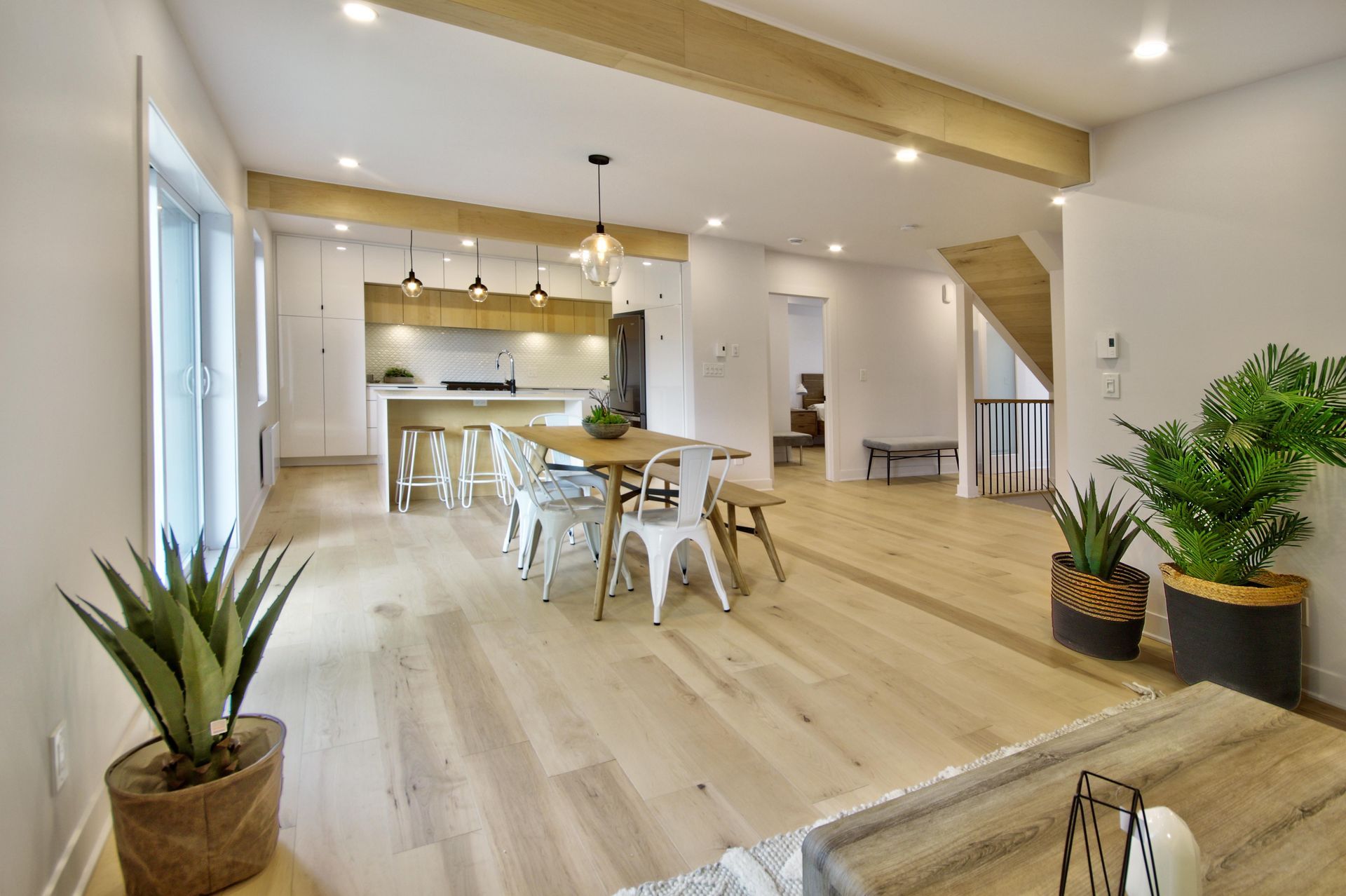 A living room filled with furniture and potted plants.