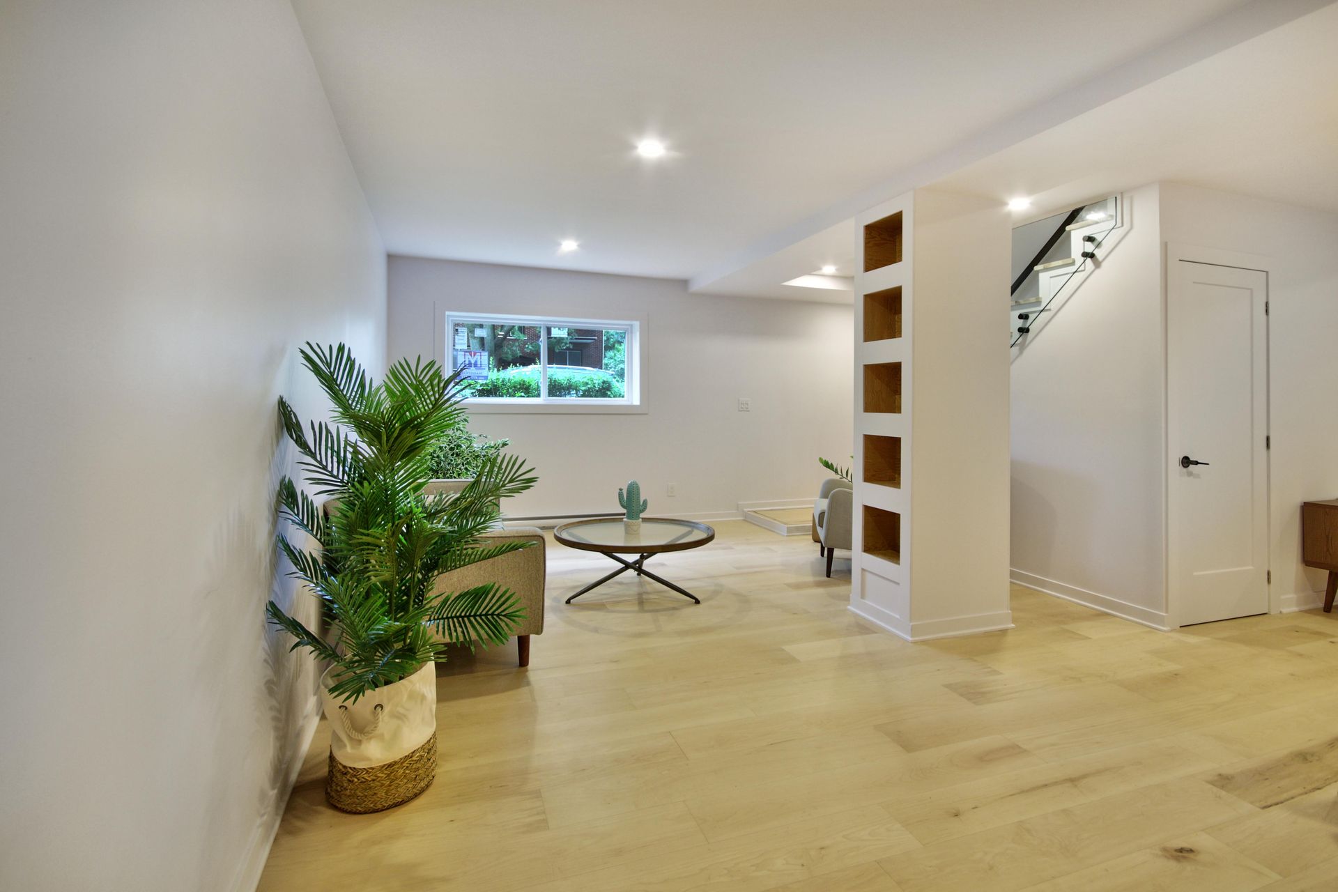 A living room with a couch , table , and potted plant.