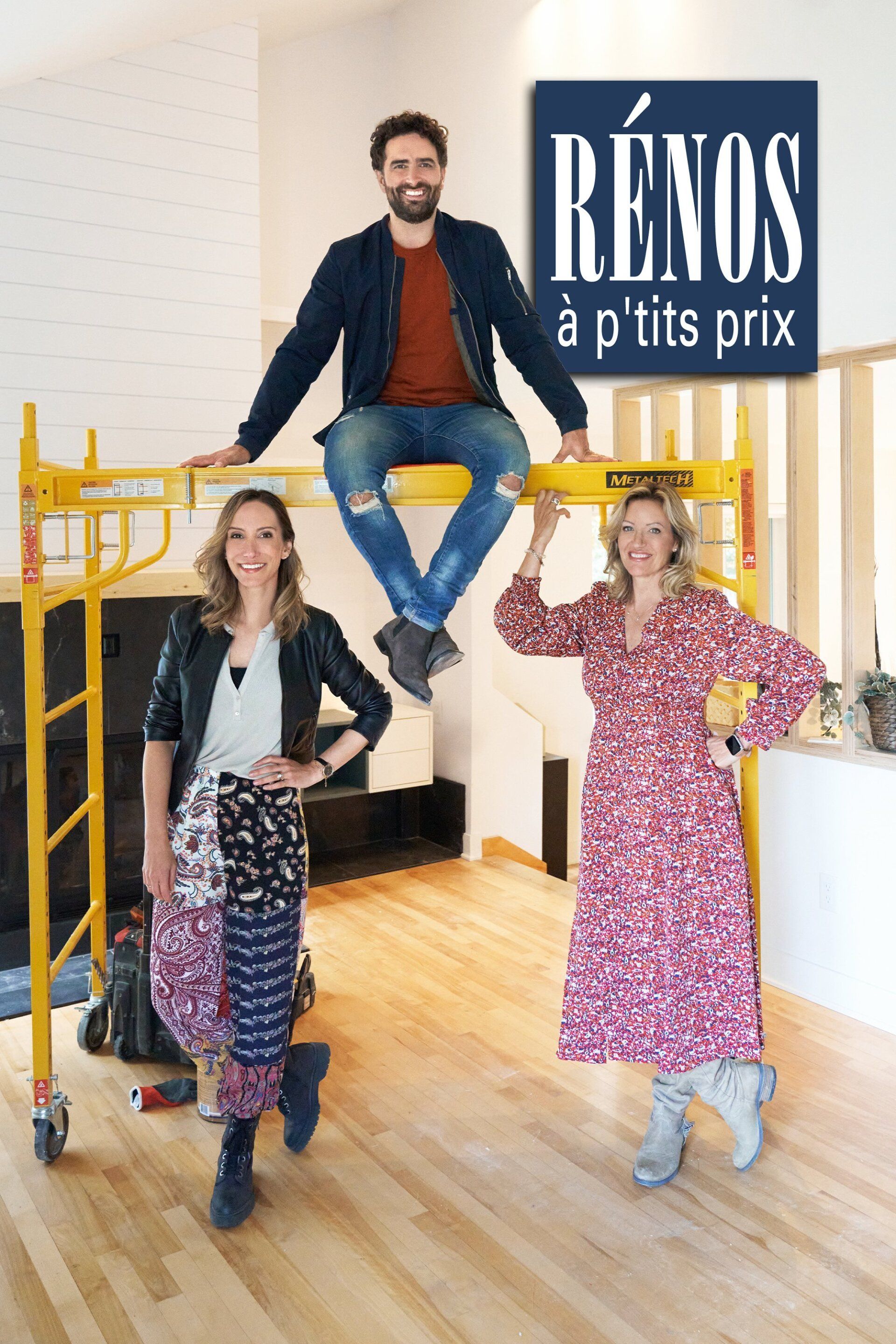 A man is sitting on a scaffolding next to two women.