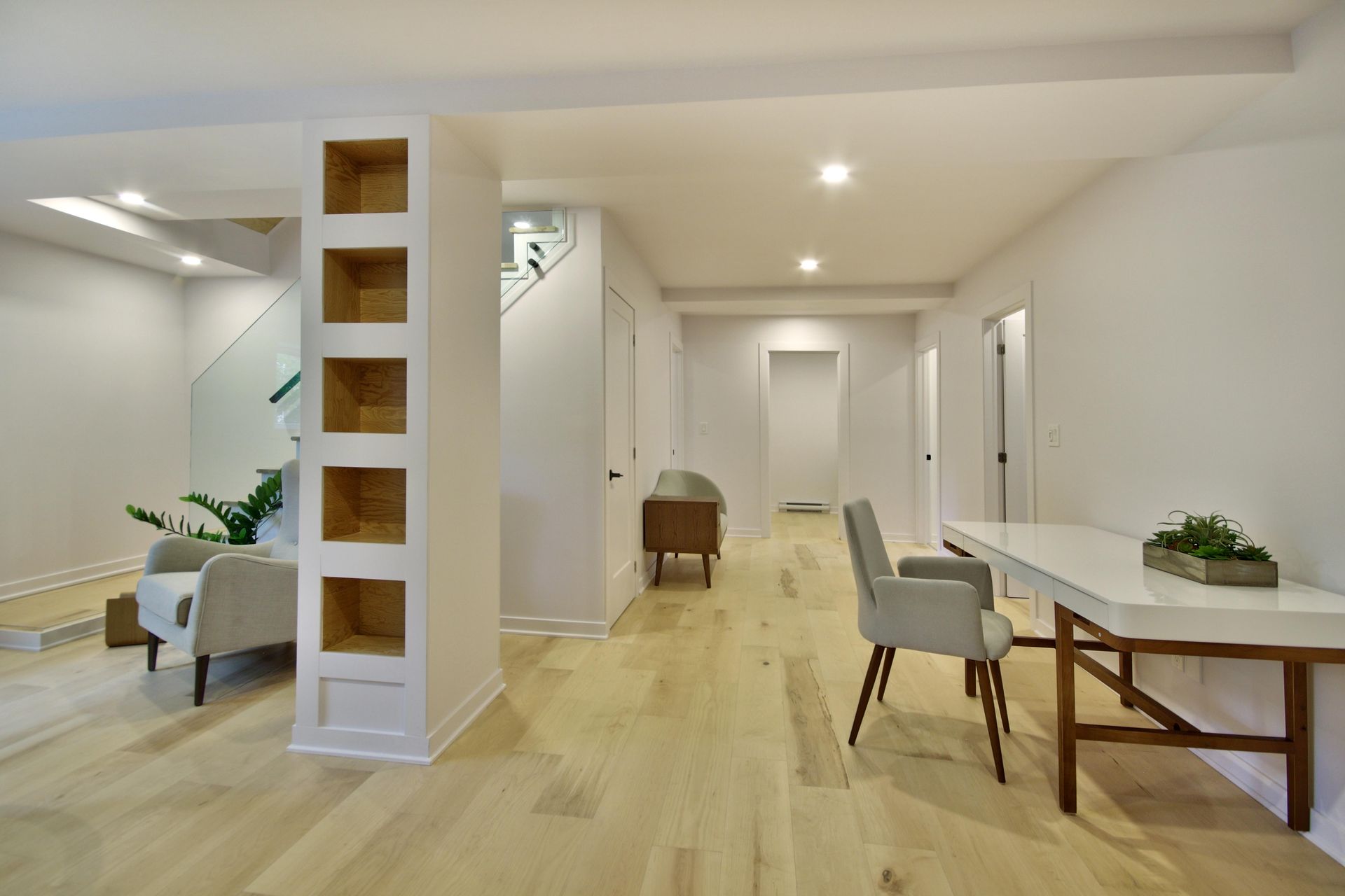 There is a desk and chairs in the middle of the room.