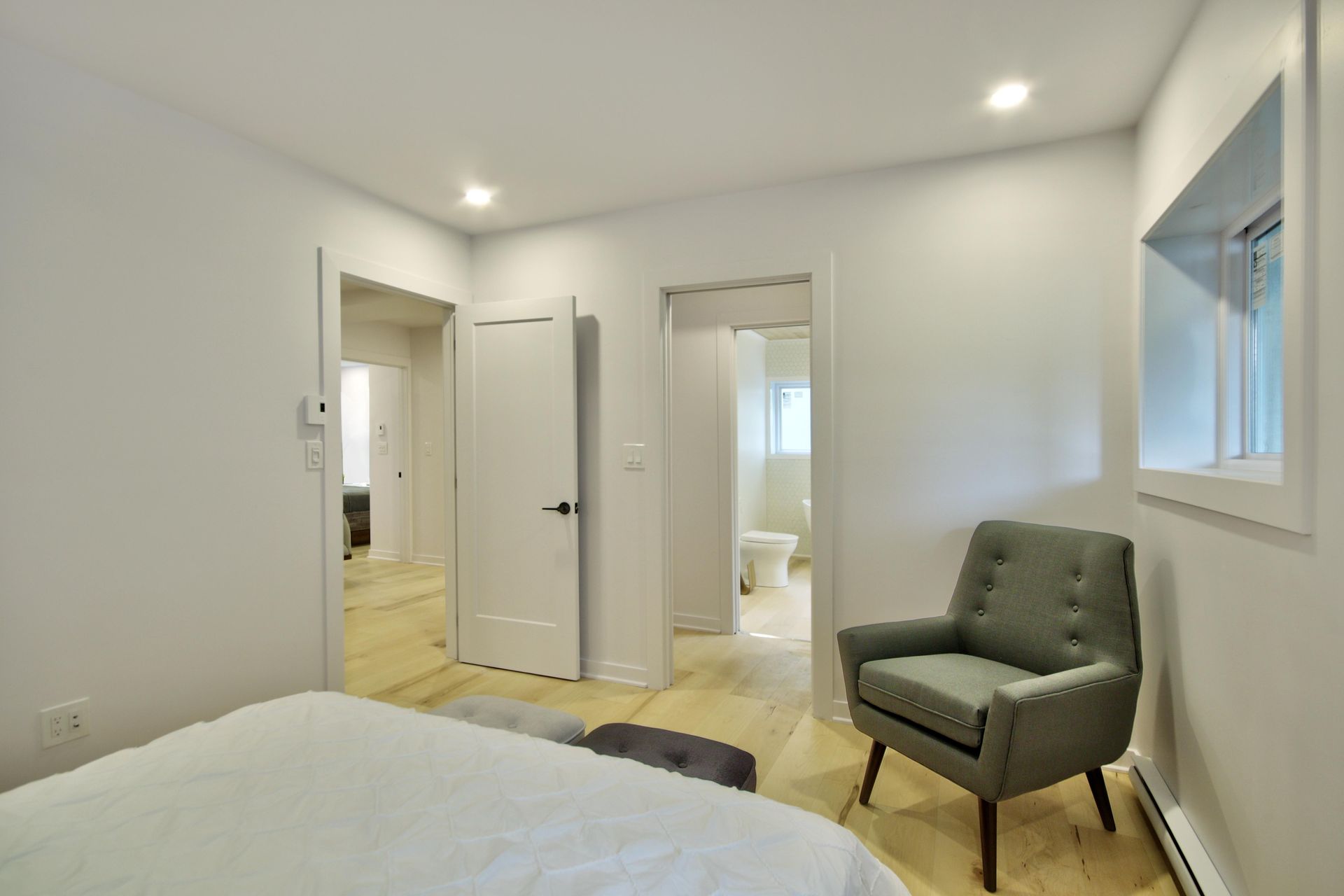 A bedroom with a bed , chair , and window.