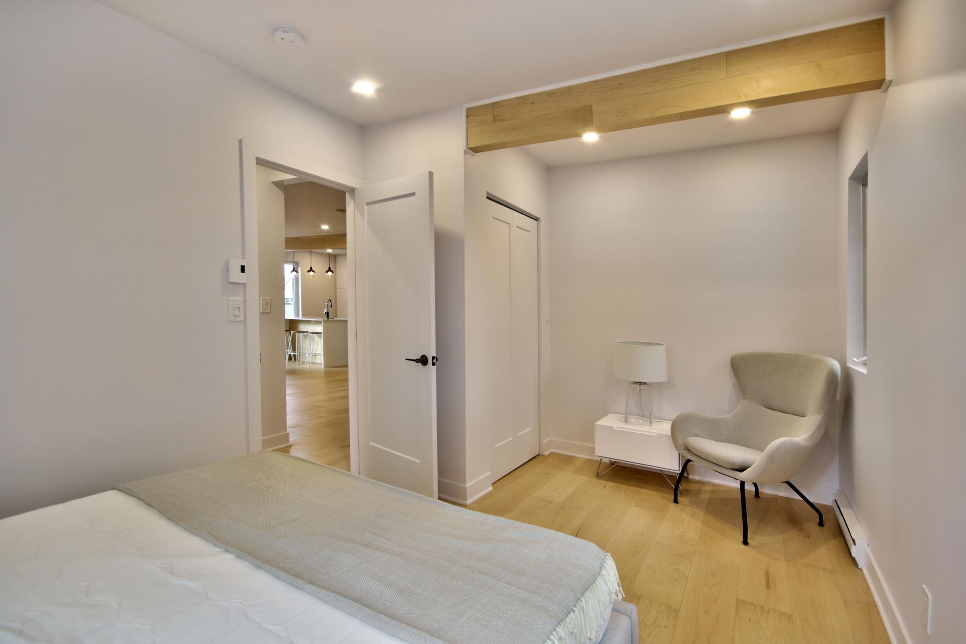 A bedroom with a bed , chair and lamp.