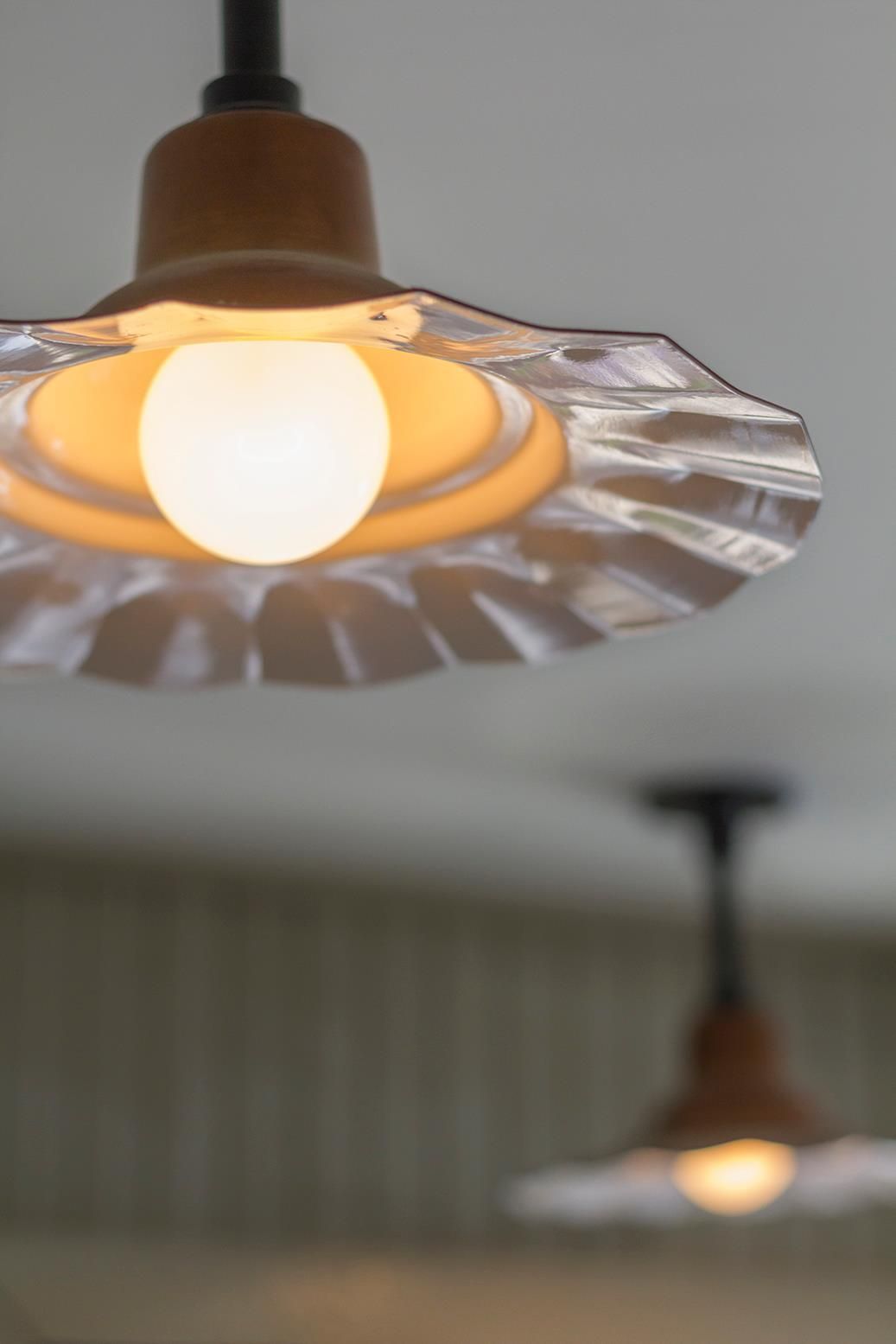 Two pendant lights are hanging from the ceiling in a kitchen.