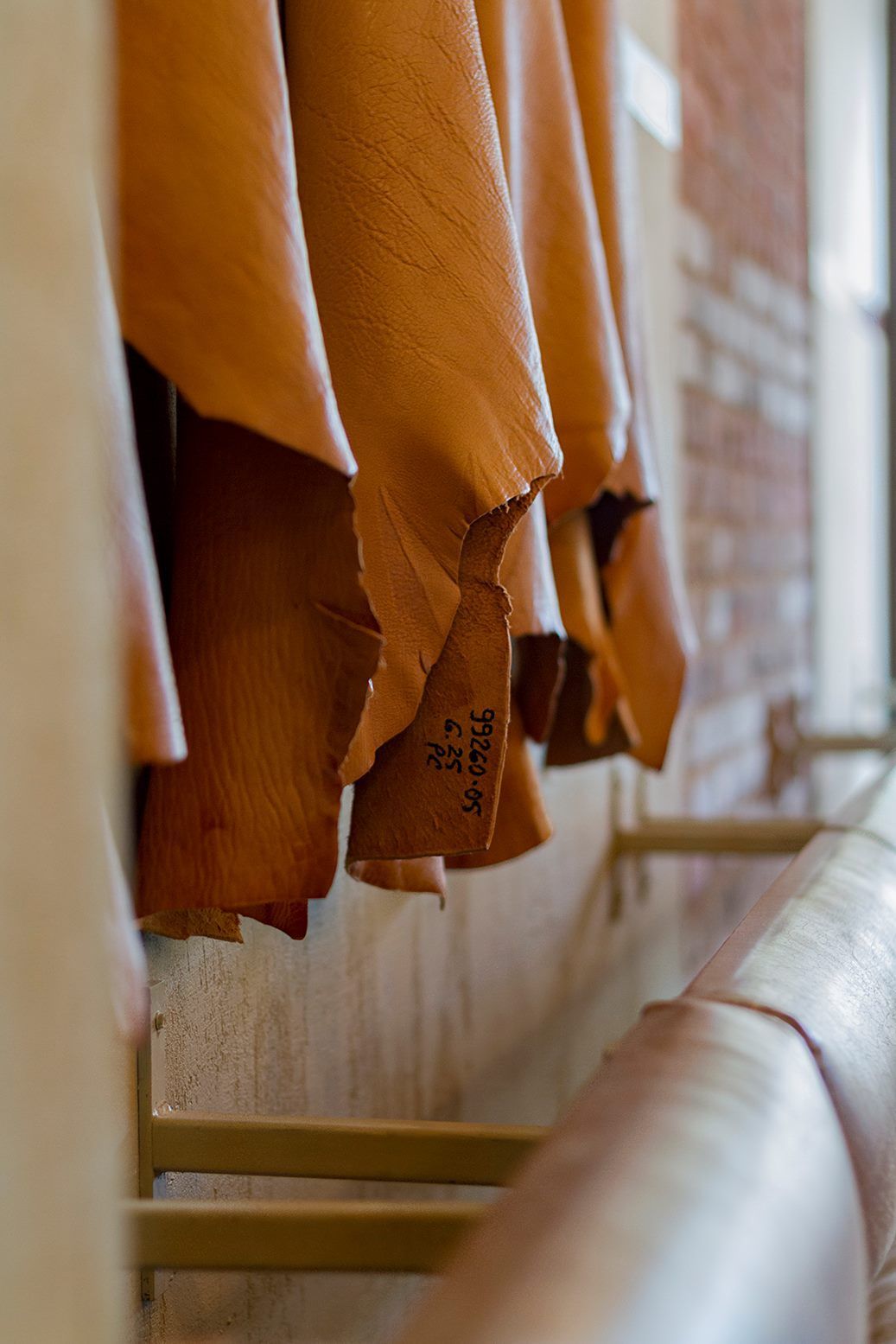 A bunch of brown leather pieces hanging on a rack.