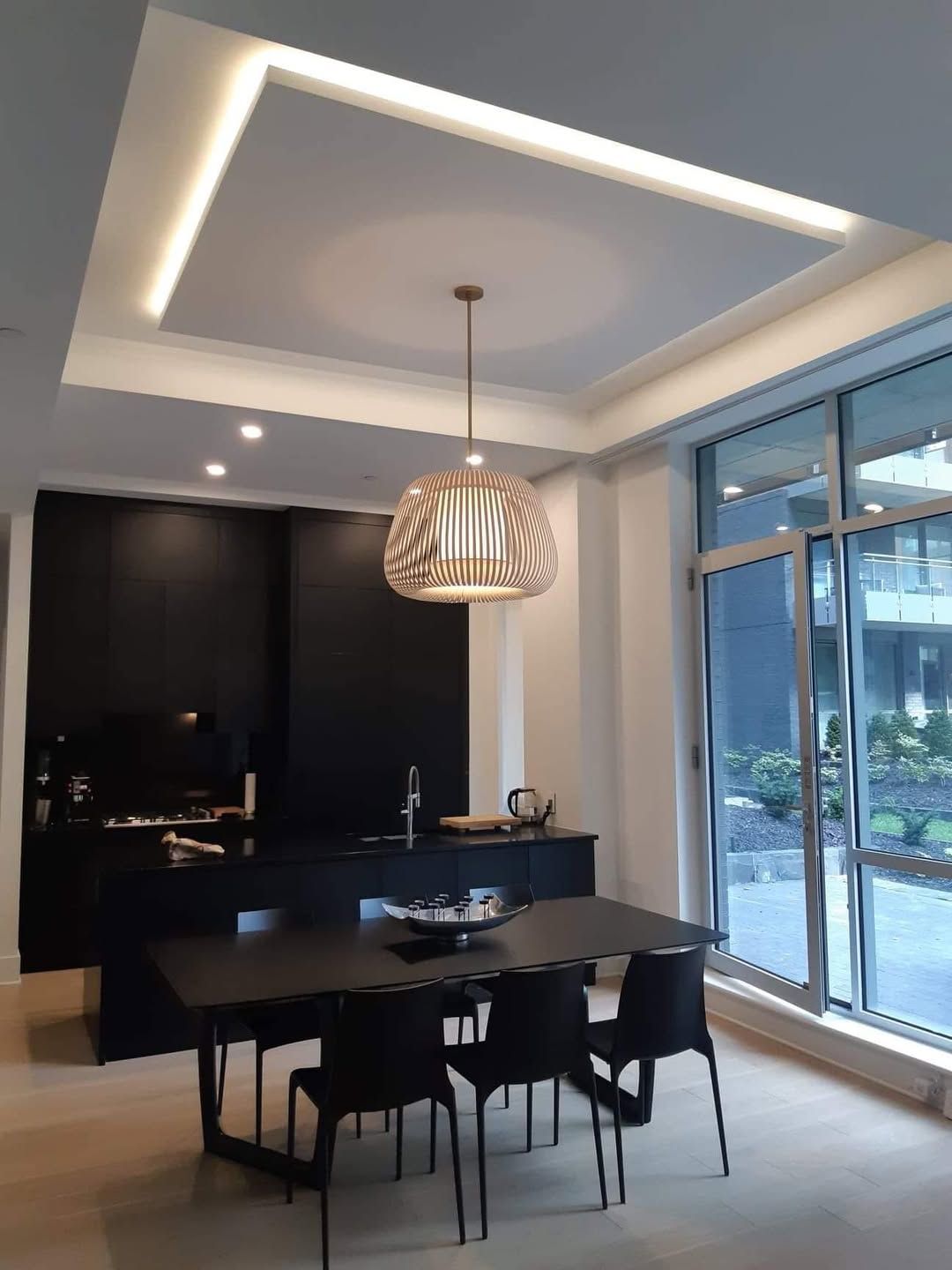 A dining room with a table and chairs and a chandelier hanging from the ceiling.