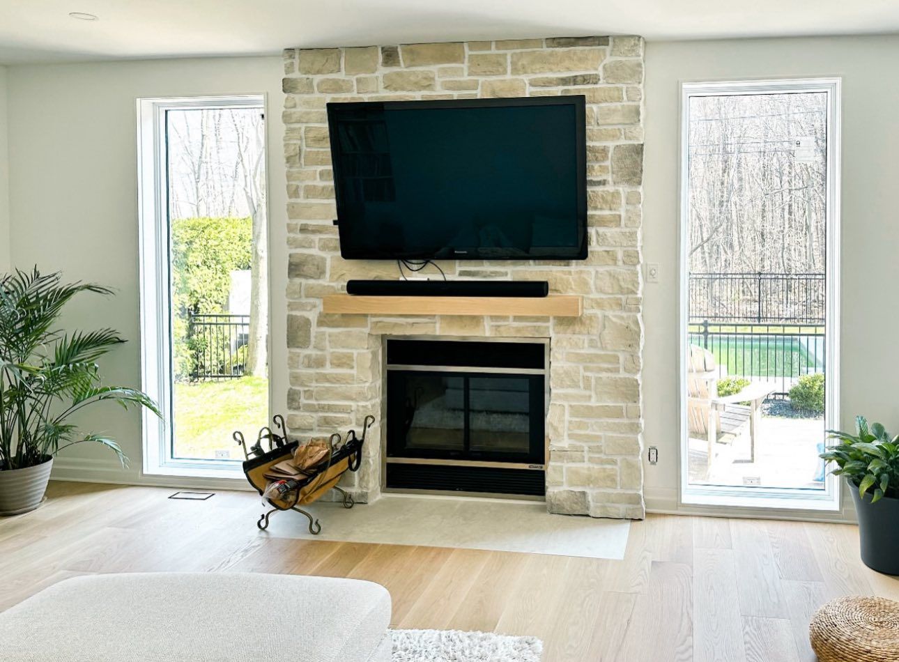 A living room with a fireplace and a flat screen tv on the wall.