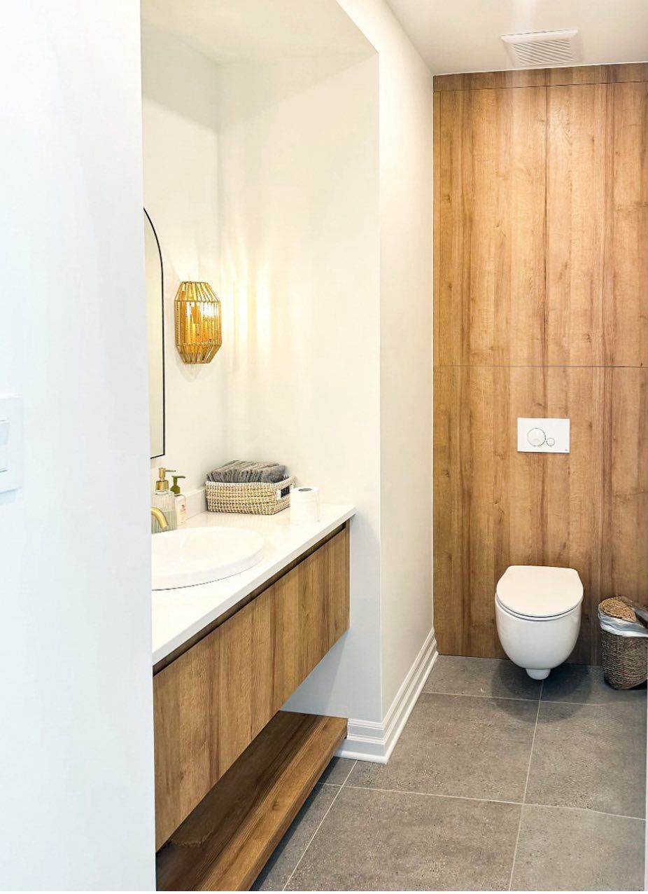 A bathroom with a toilet , sink and mirror