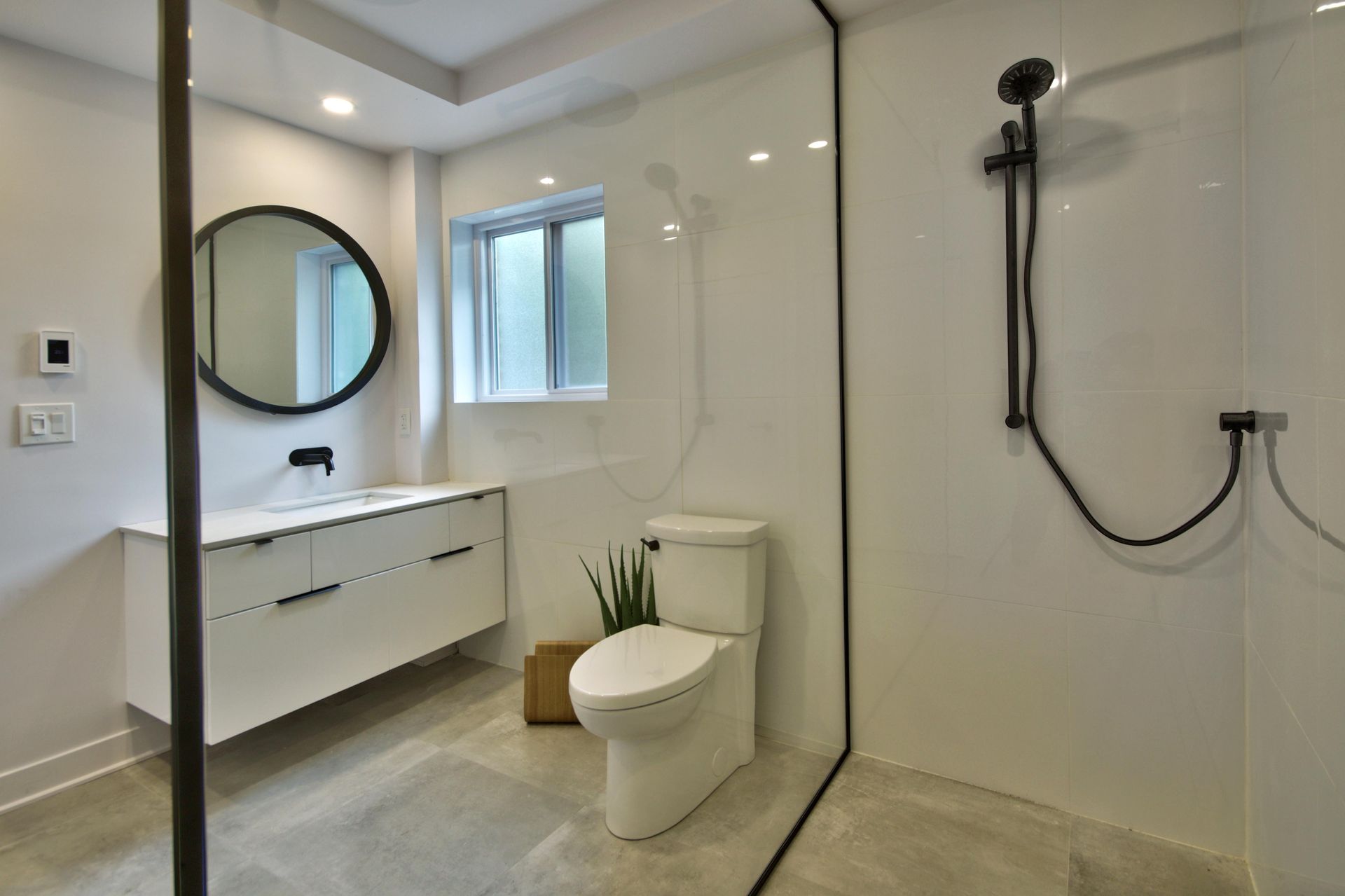 A bathroom with a toilet , sink and shower.