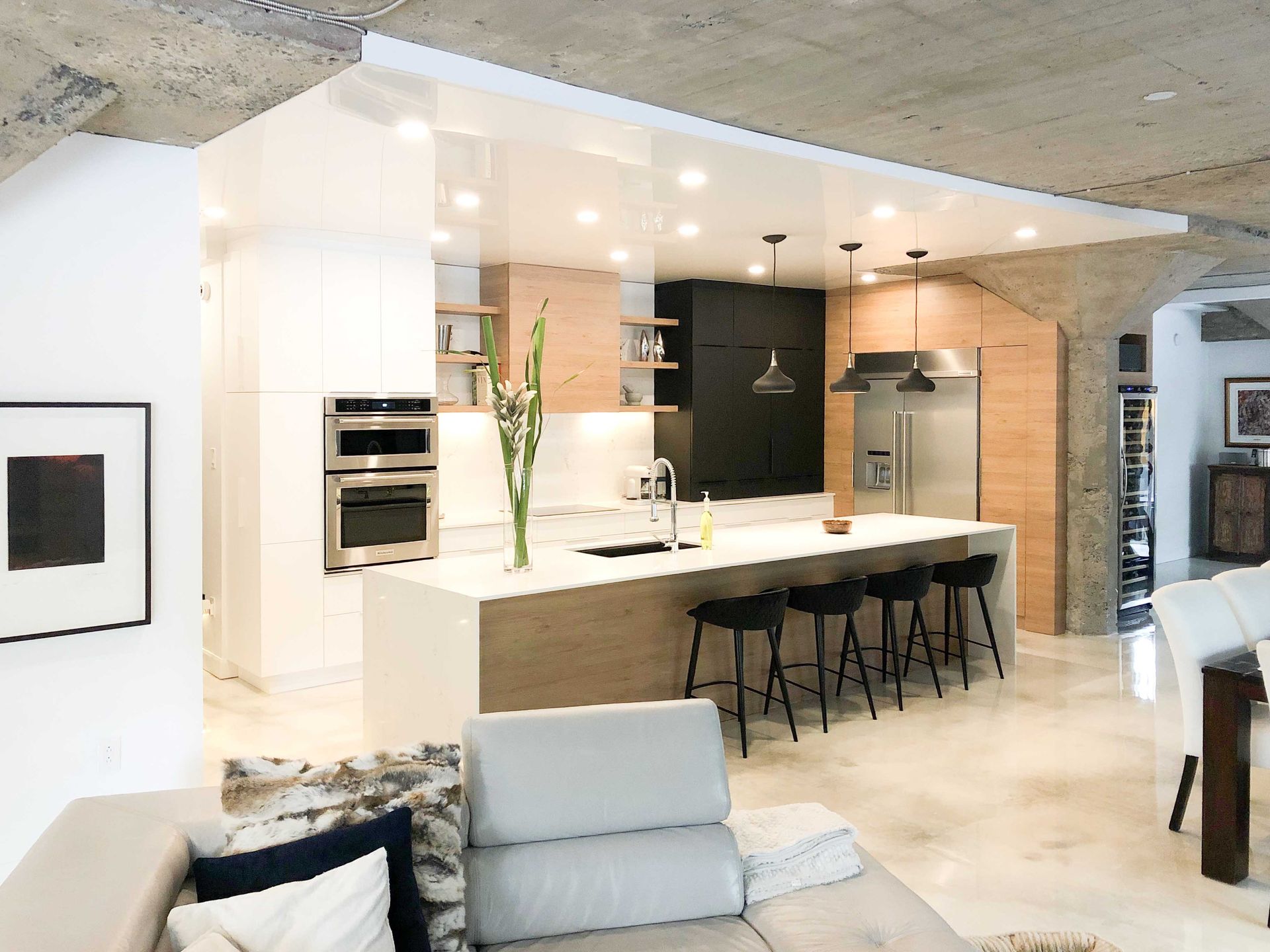 A living room filled with furniture and a kitchen with a large island.
