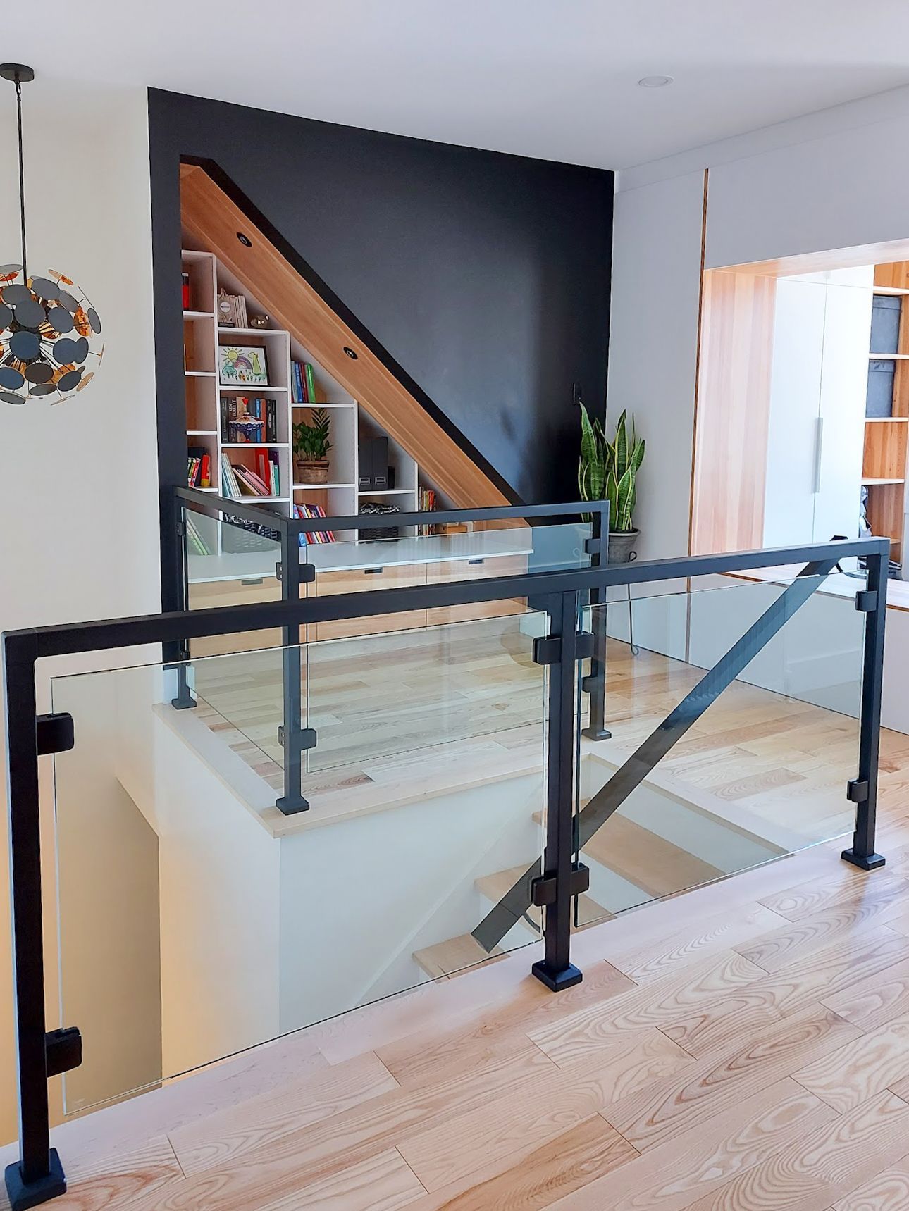 A staircase with a glass railing and a black railing