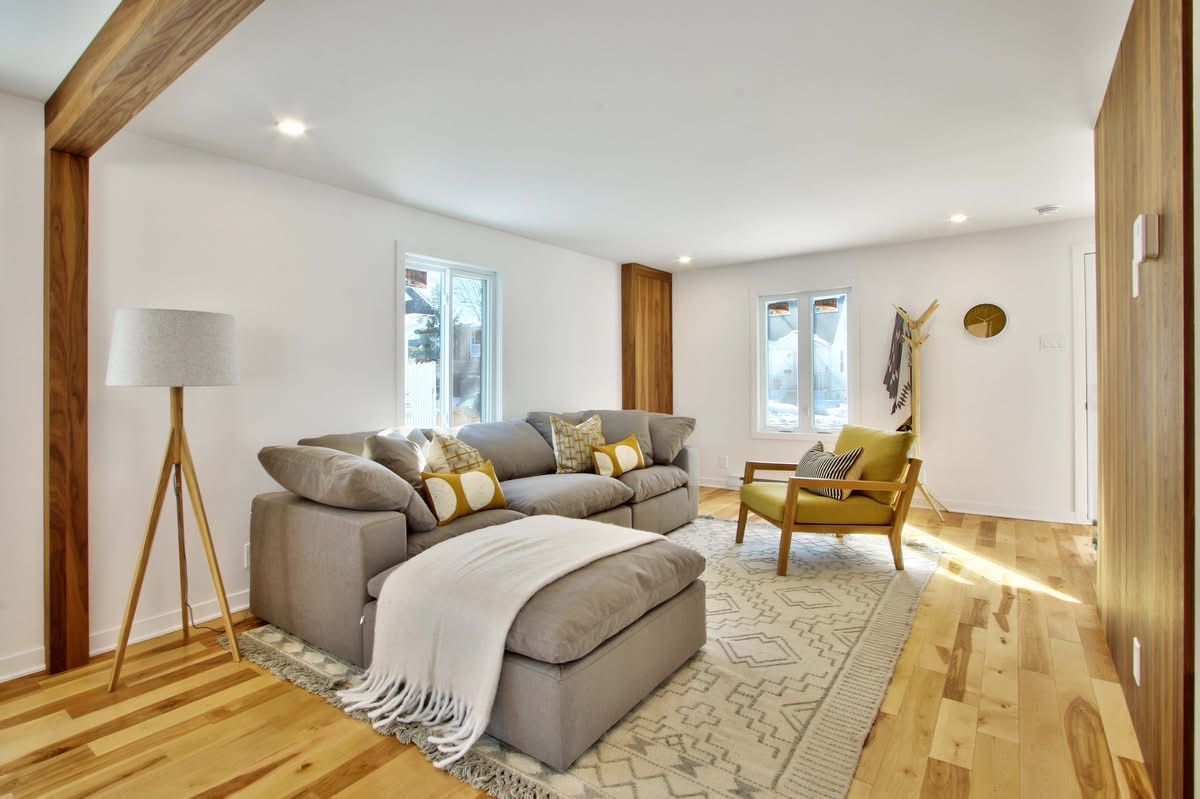 A living room with a couch , chair , lamp and rug.
