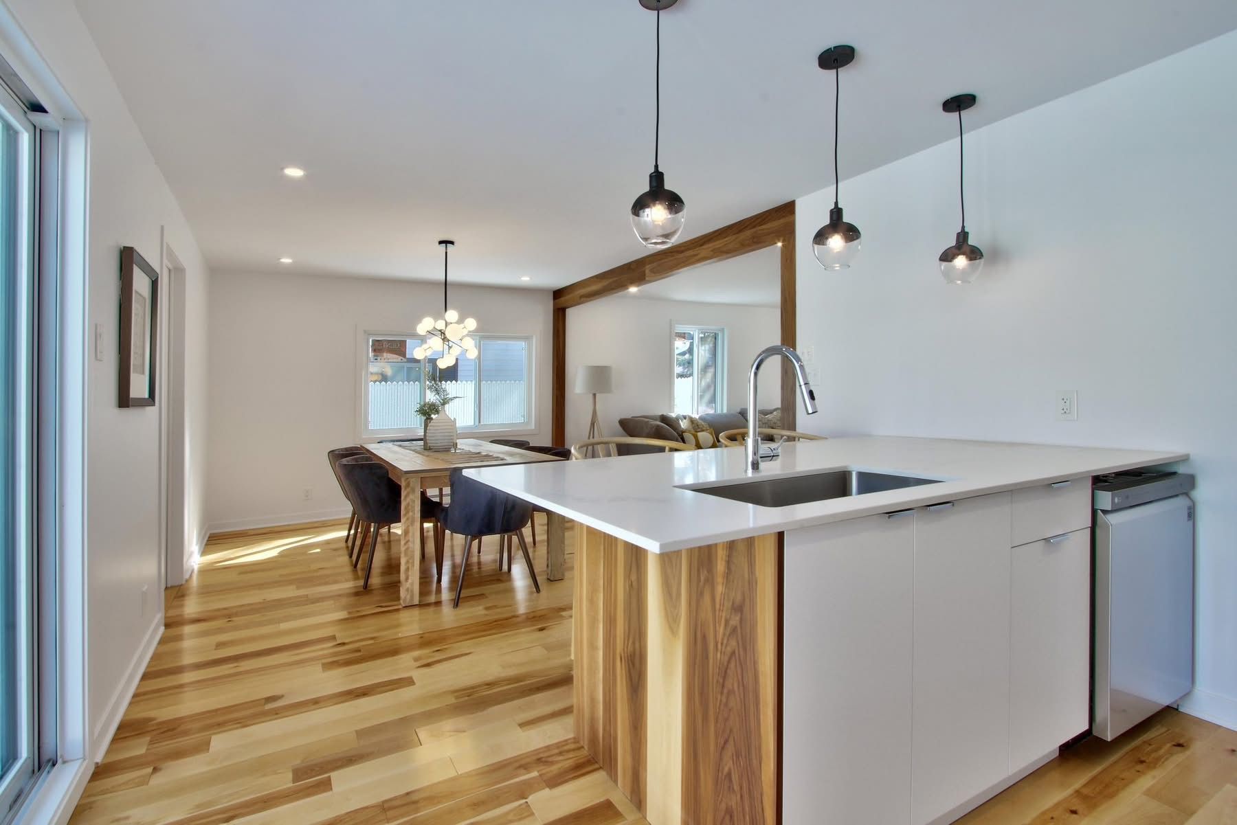 A kitchen with a large island , a sink , a table and chairs.