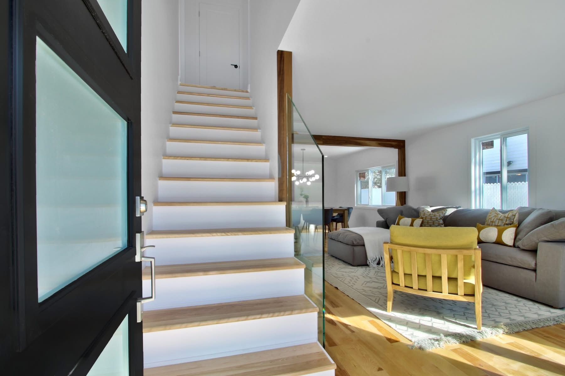 A staircase leading up to a living room in a house.