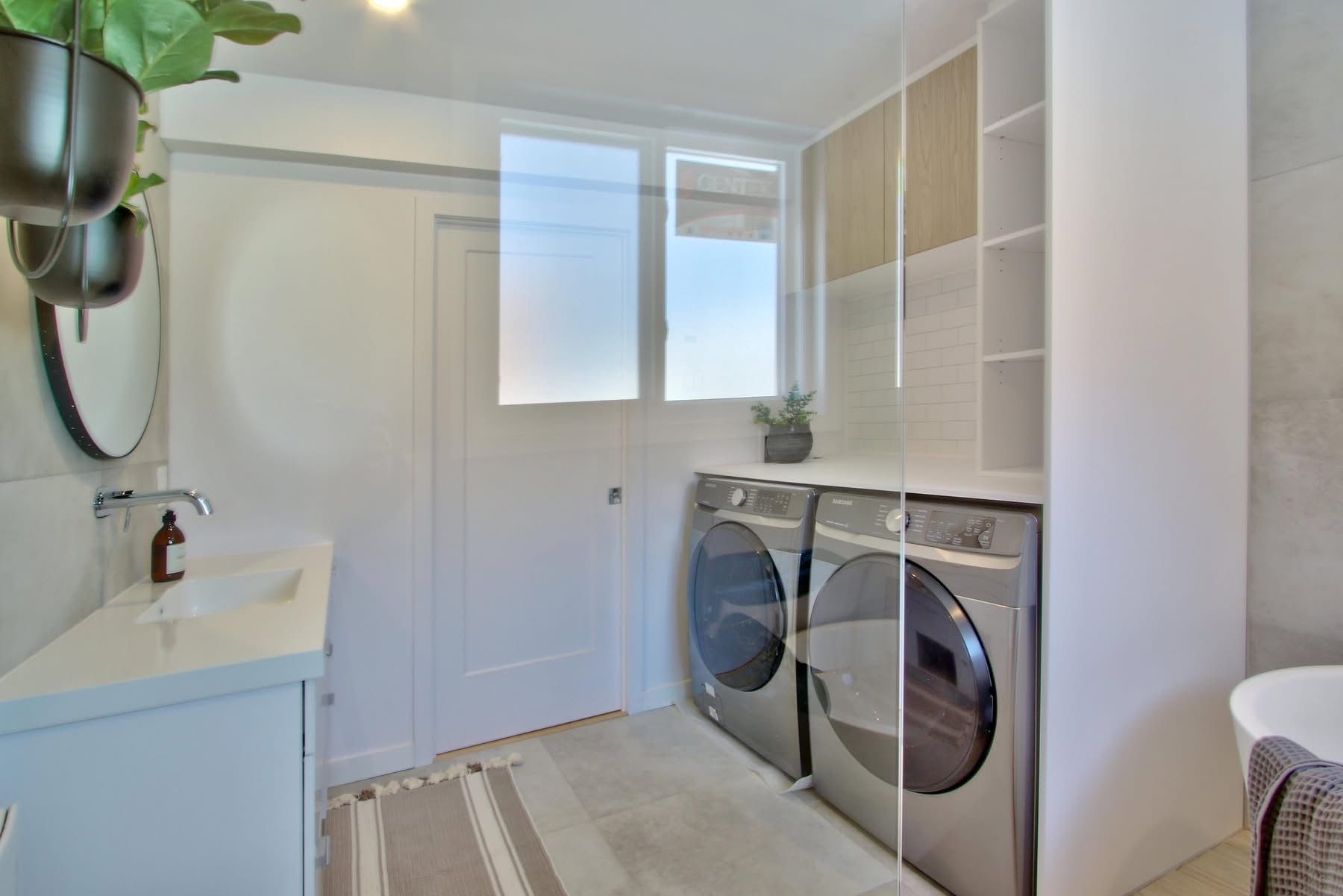 A laundry room with a washer and dryer and a sink.