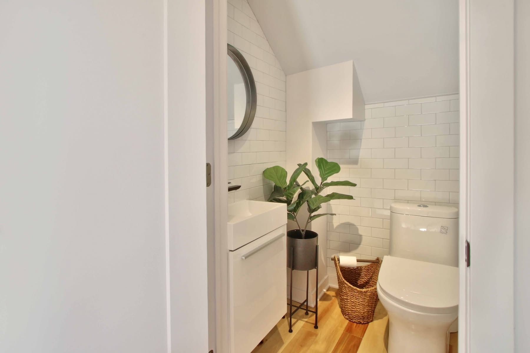 A bathroom with a toilet , sink and mirror.