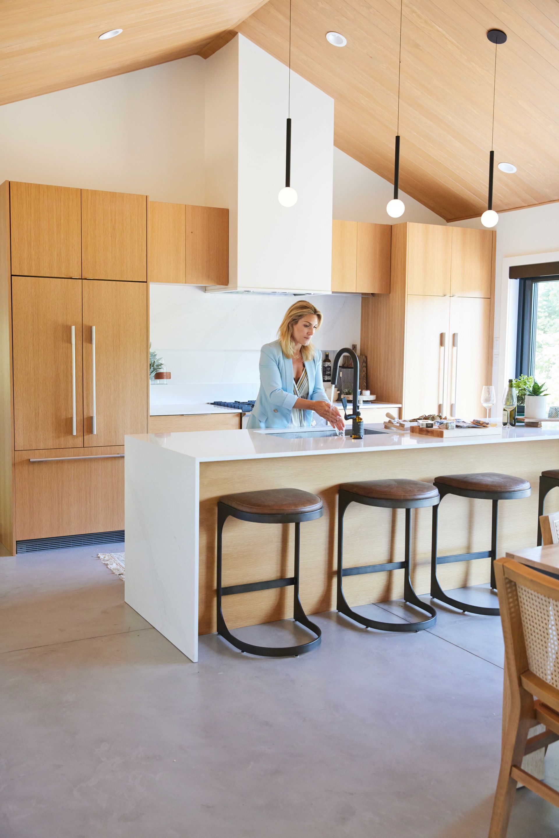 A woman is standing at a counter in a kitchen.