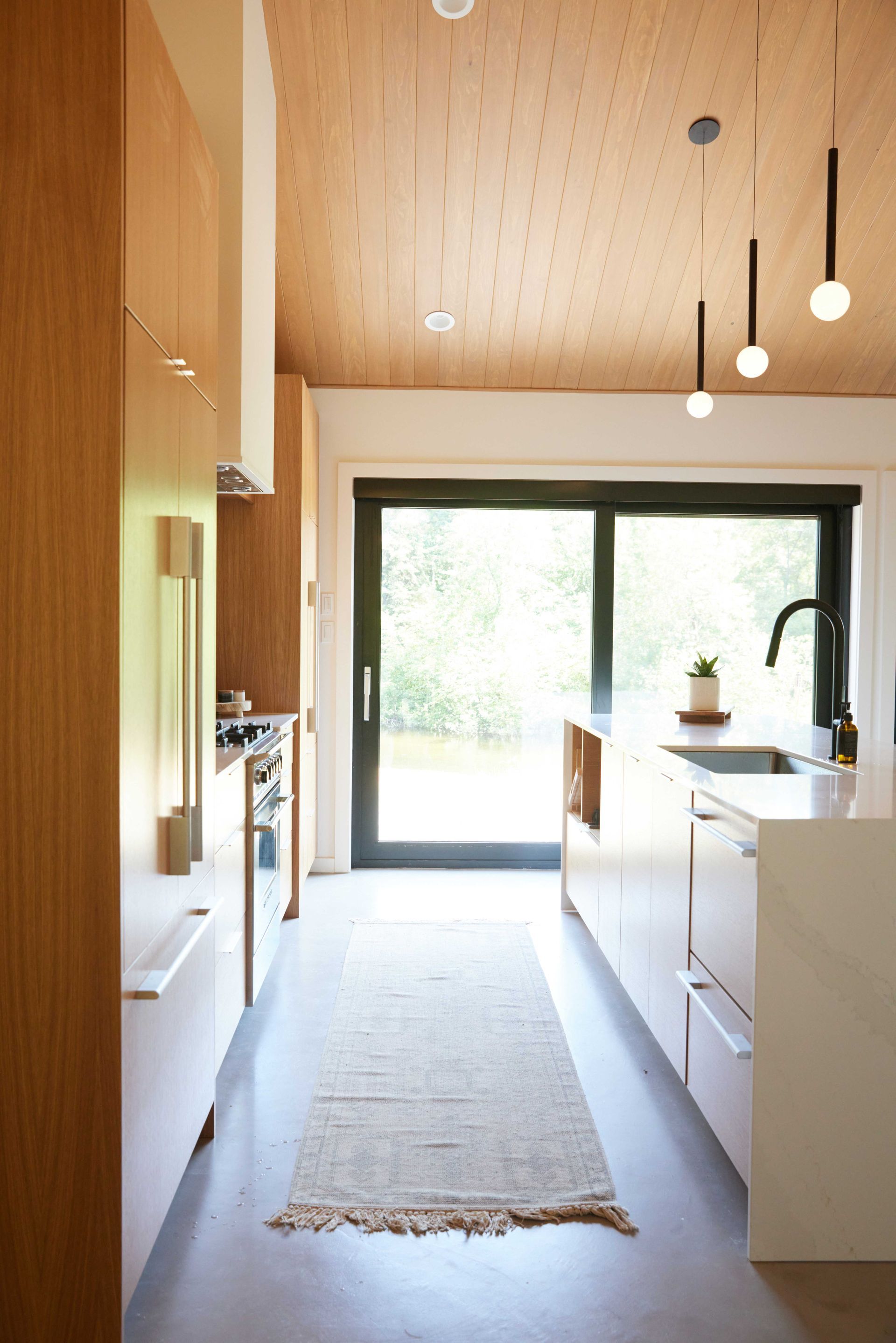 A kitchen with a sliding glass door and a rug on the floor.
