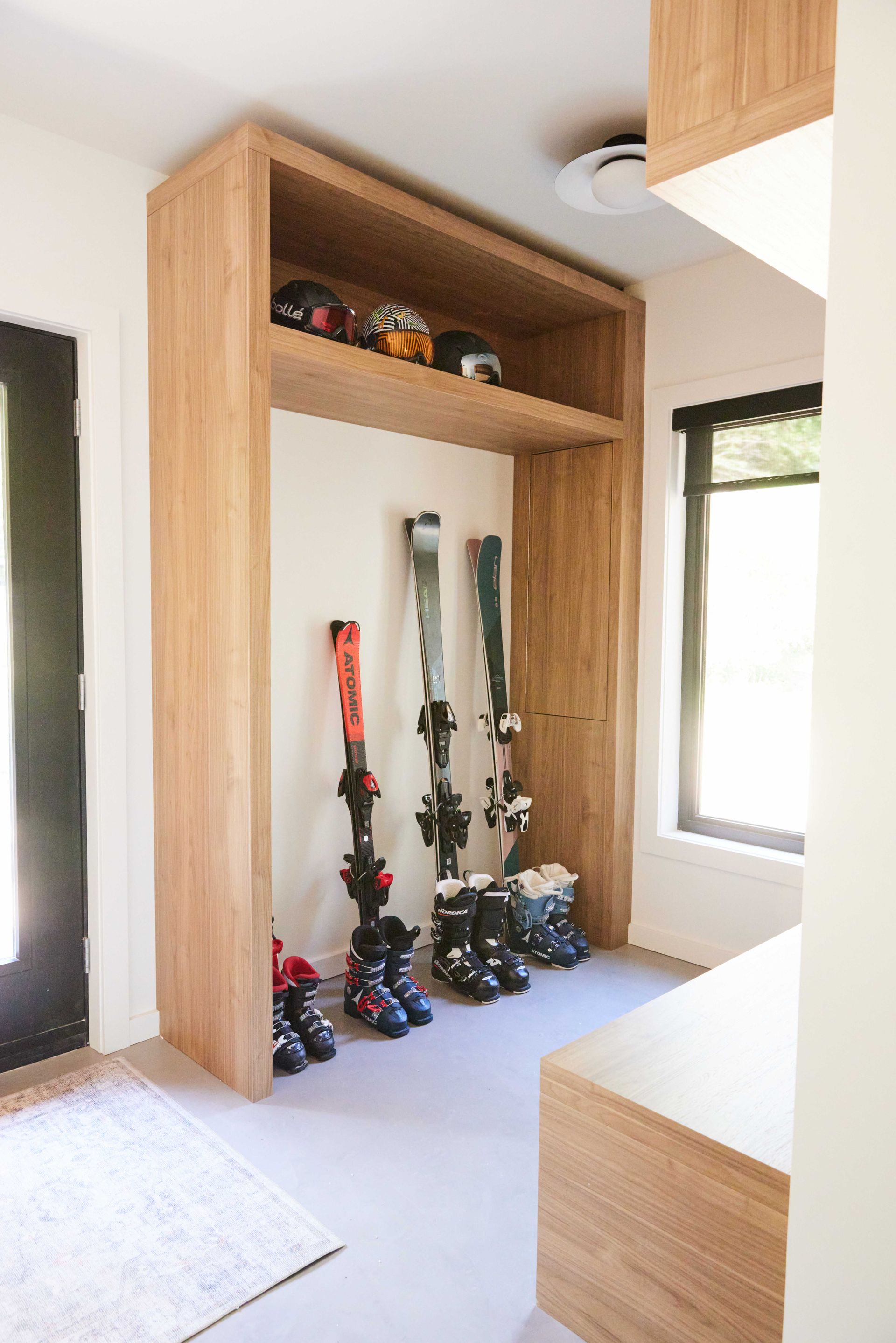 A room with skis and boots hanging on the wall.