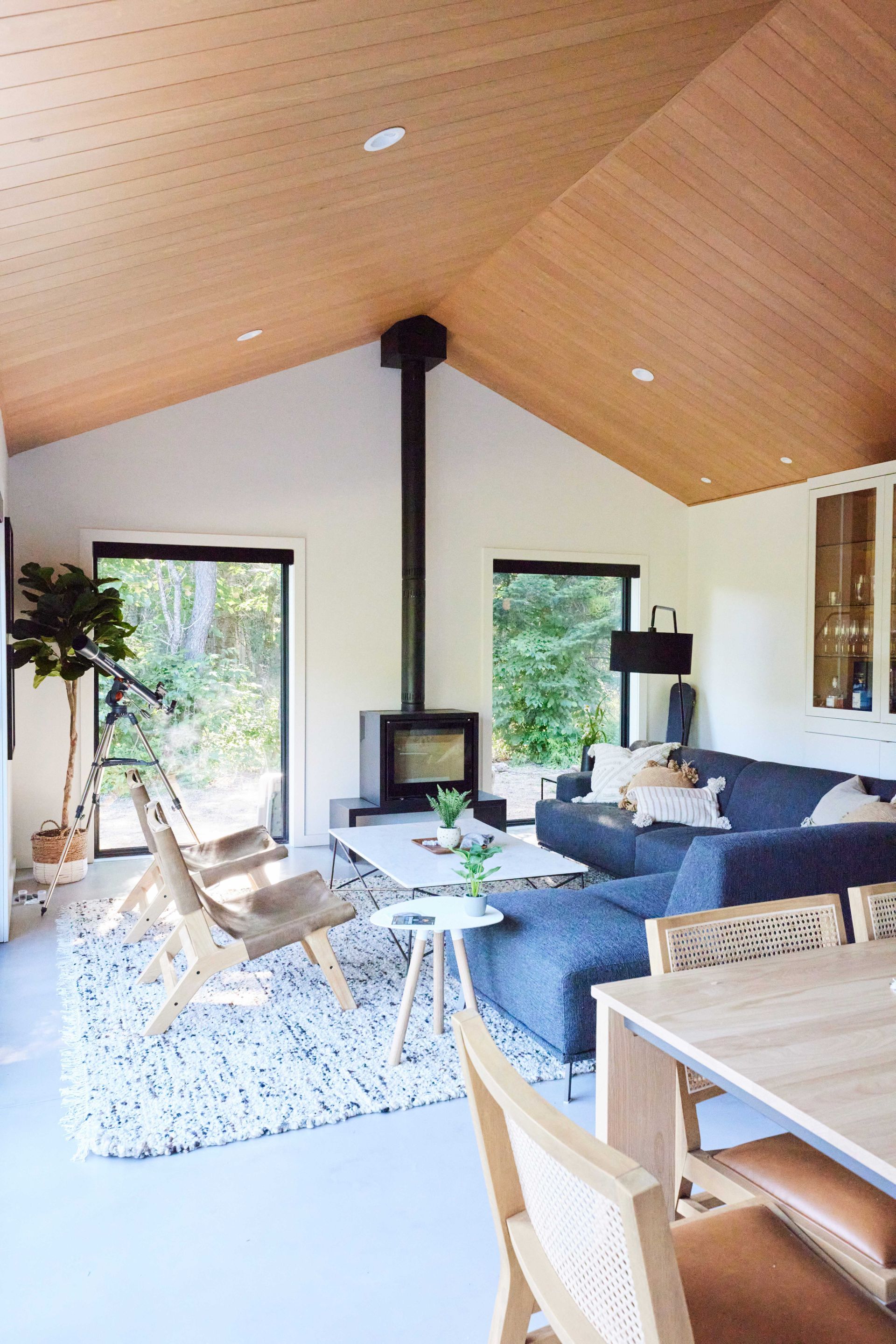 A living room with a couch , chairs , a table and a fireplace.
