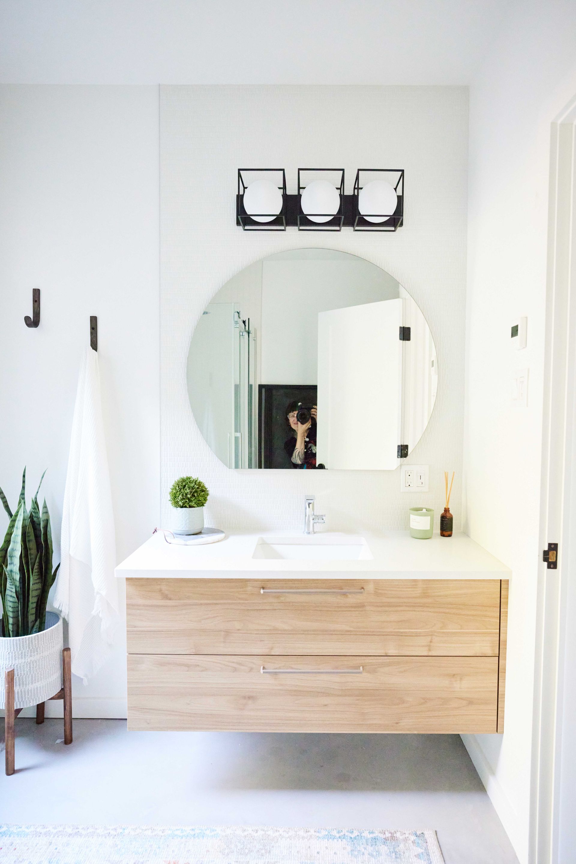 A bathroom with a sink and a round mirror.