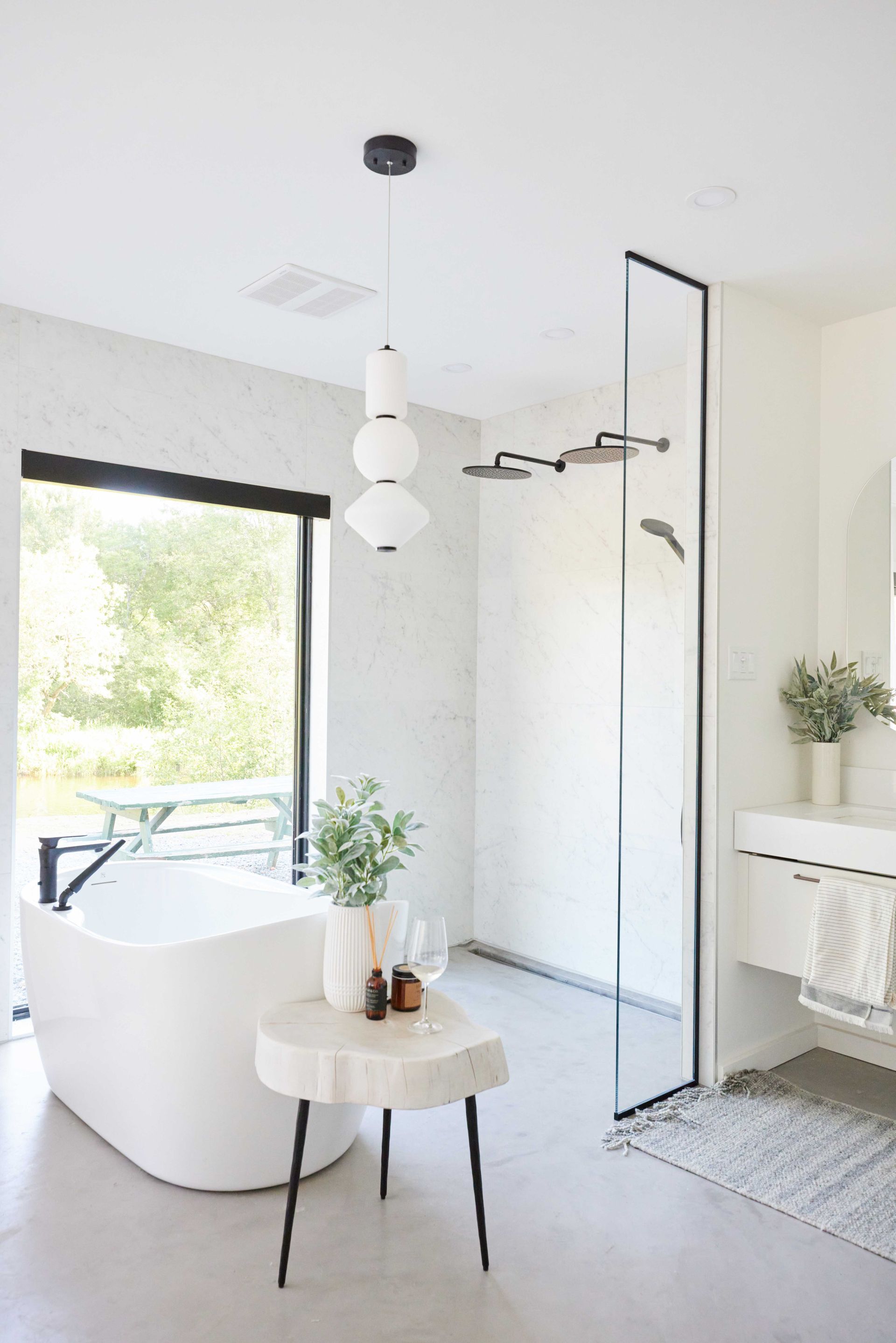 A bathroom with a tub , sink , mirror and walk in shower.