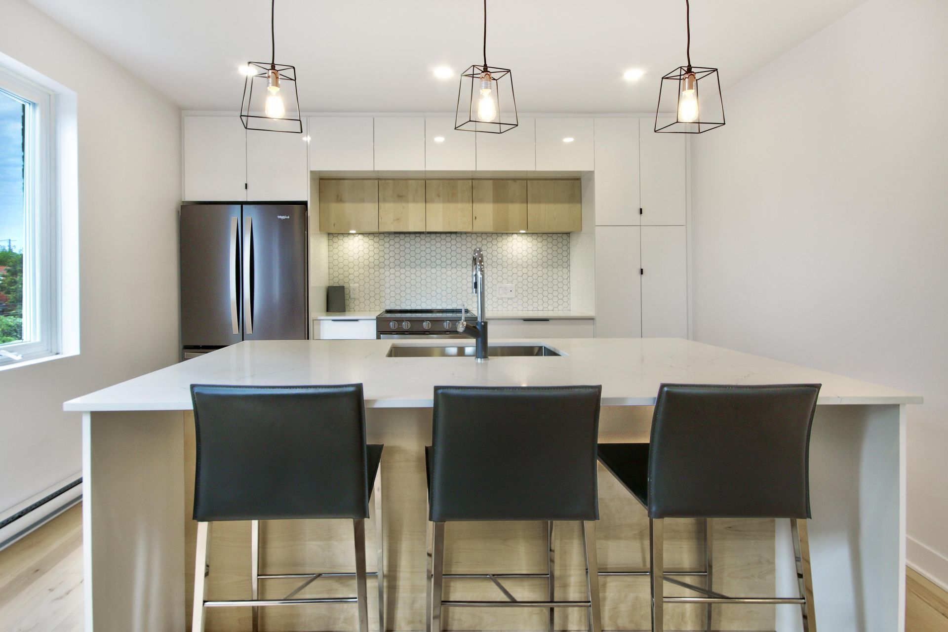 A kitchen with a large island and stools