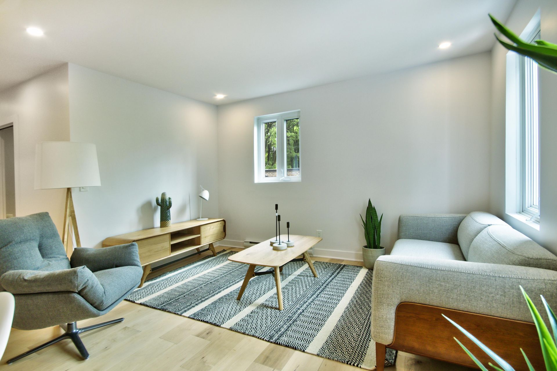 A living room with a couch , chair , coffee table and rug.