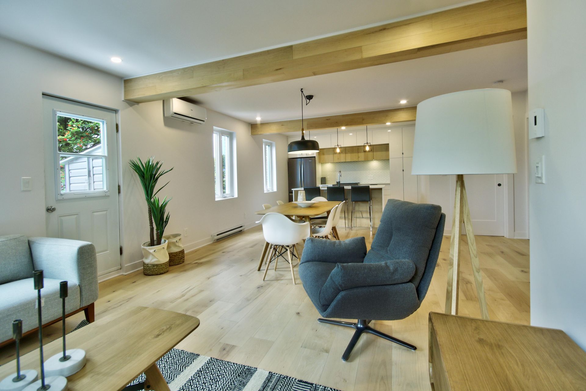 A living room with a couch , chair , table and lamp.