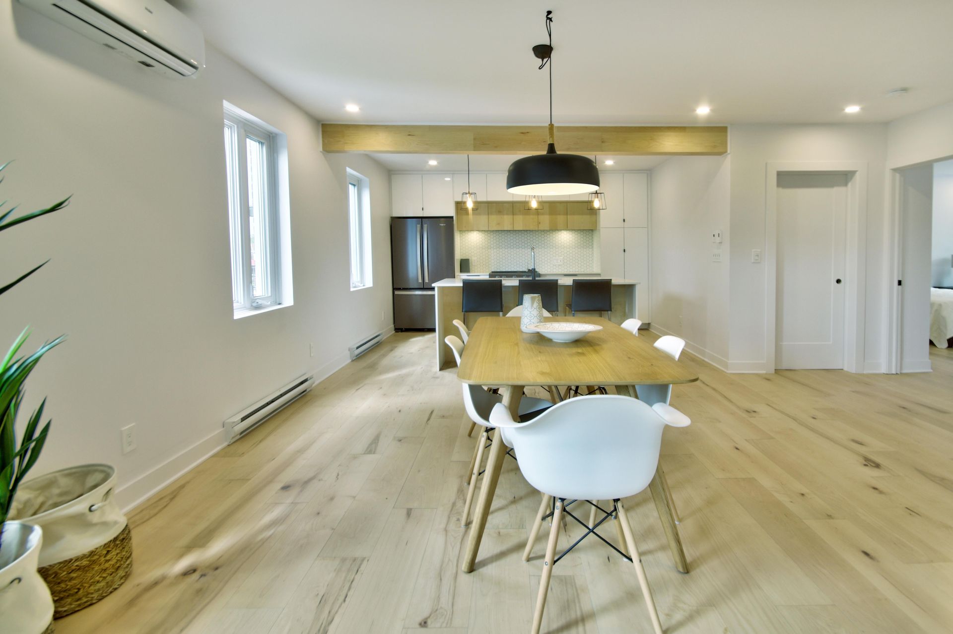 A dining room with a wooden table and white chairs