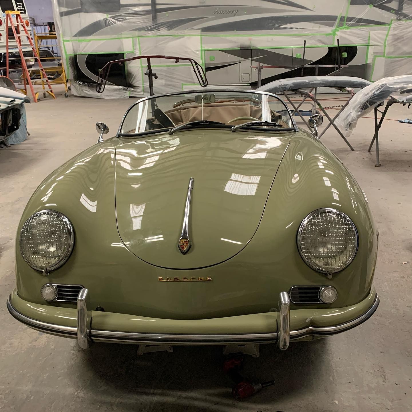 Green Porsche 356 convertible in a body shop.