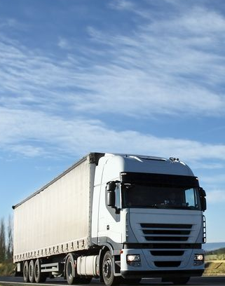 White Semi-truck Driving on a Road Under a Blue Sky, Flanked by Grassy Fields — Hines Logistic Pty Ltd In Inverell, NSW