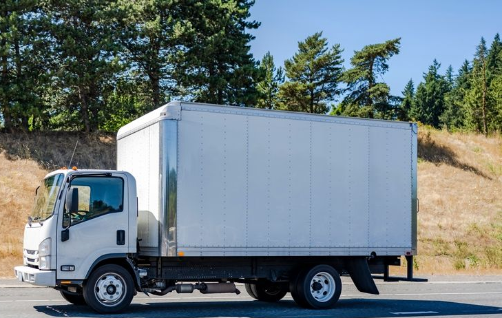 White Box Truck Driving on a Highway, Trees in the Background, Sunny Day — Hines Logistic Pty Ltd In Taree, NSW