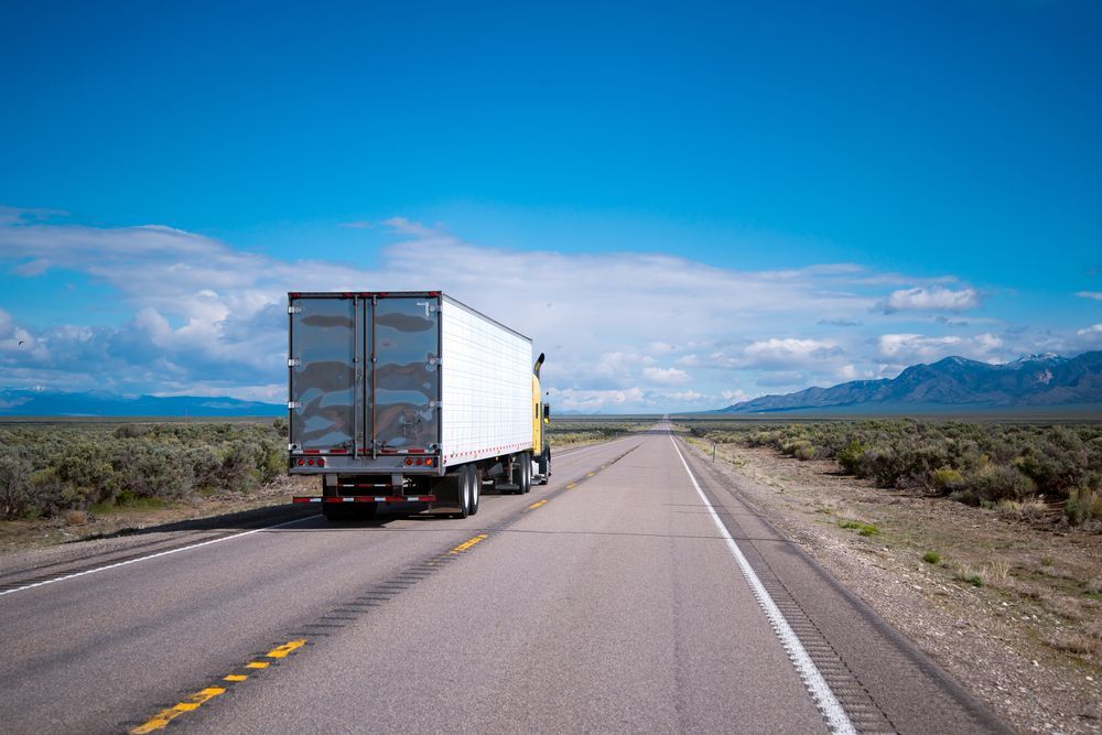 Semi-truck on a Straight Asphalt Road, Traveling Through a Desert Landscape — Hines Logistic Pty Ltd In Armidale, NSW