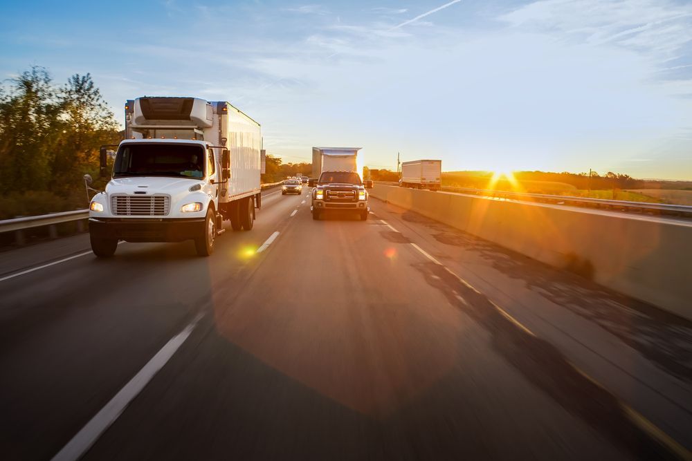 Trucks and Other Vehicles Traveling on a Highway at Sunset — Hines Logistic Pty Ltd In Kundabung, NSW